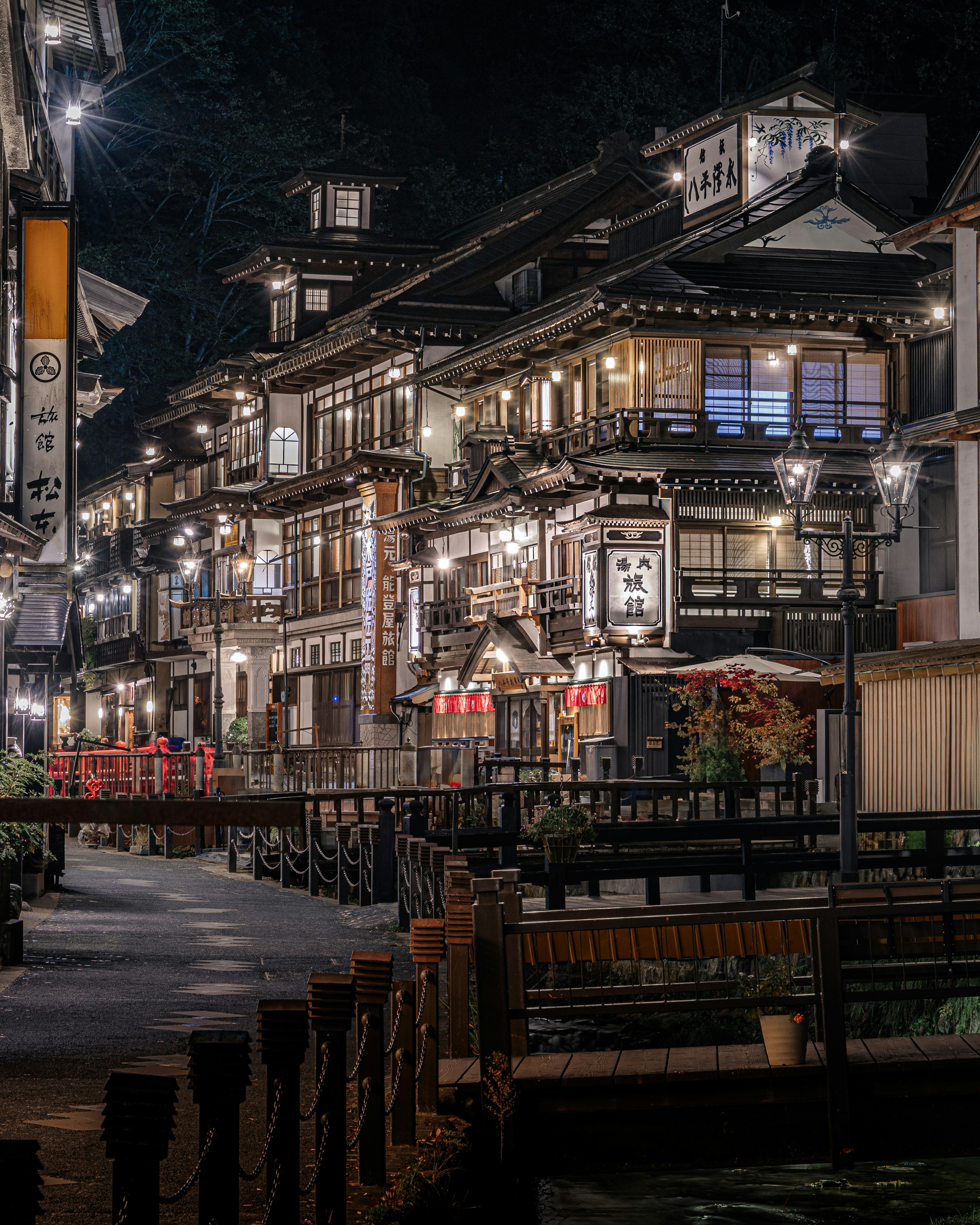 夜の温泉街の伝統的な建物が並ぶ風景