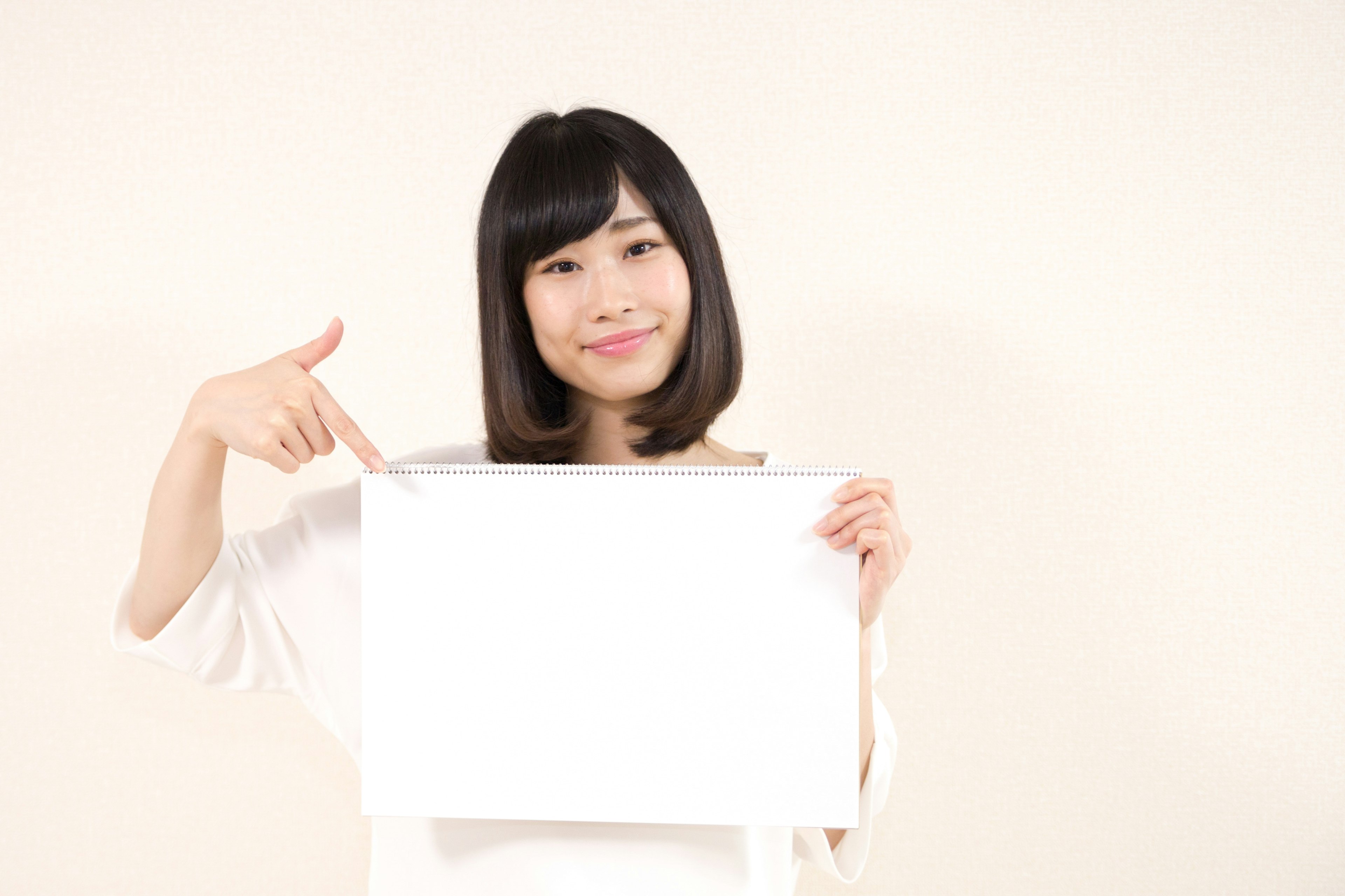 Woman smiling while holding a blank white board