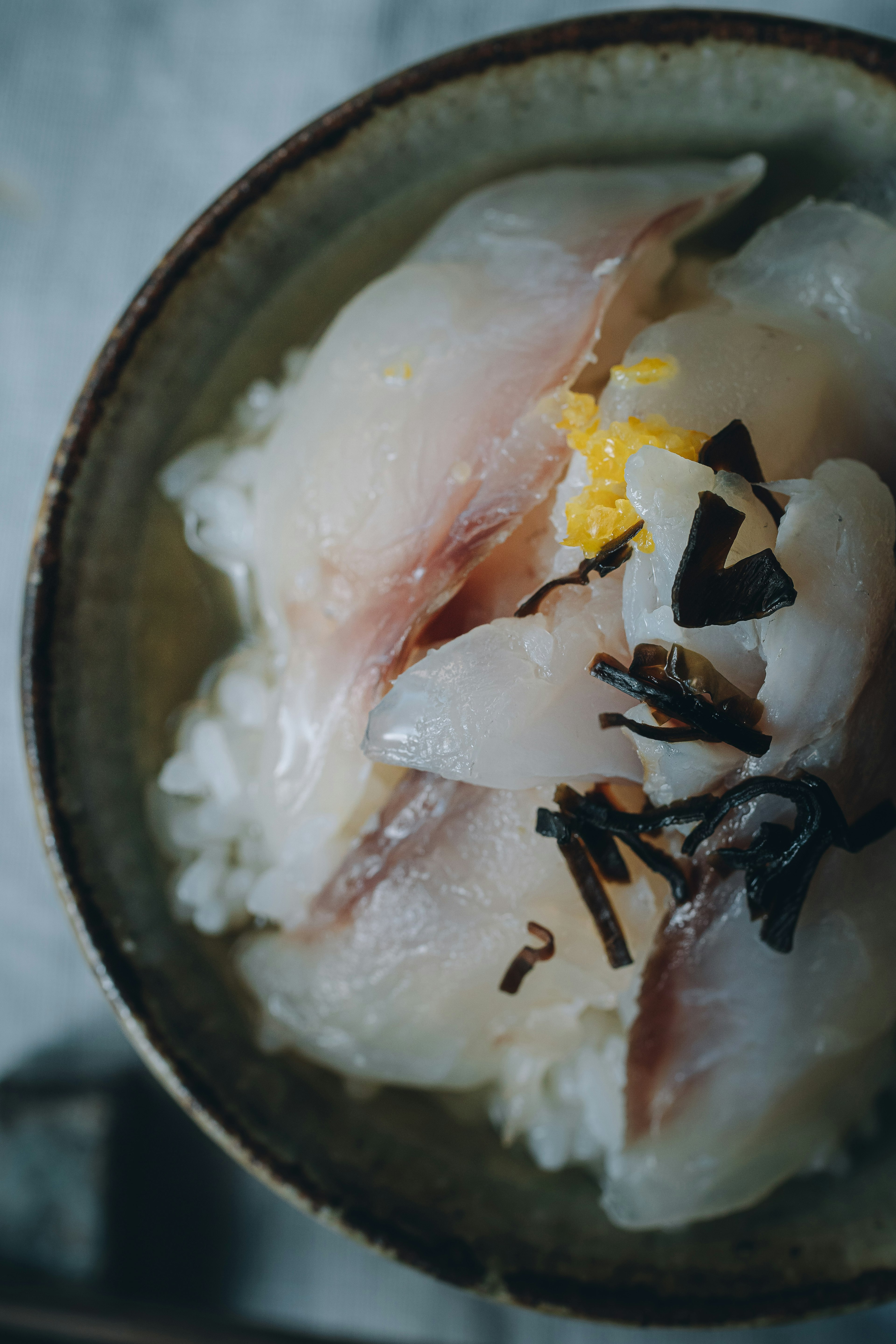 白米の上に新鮮な刺身と海苔がトッピングされた和食の丼