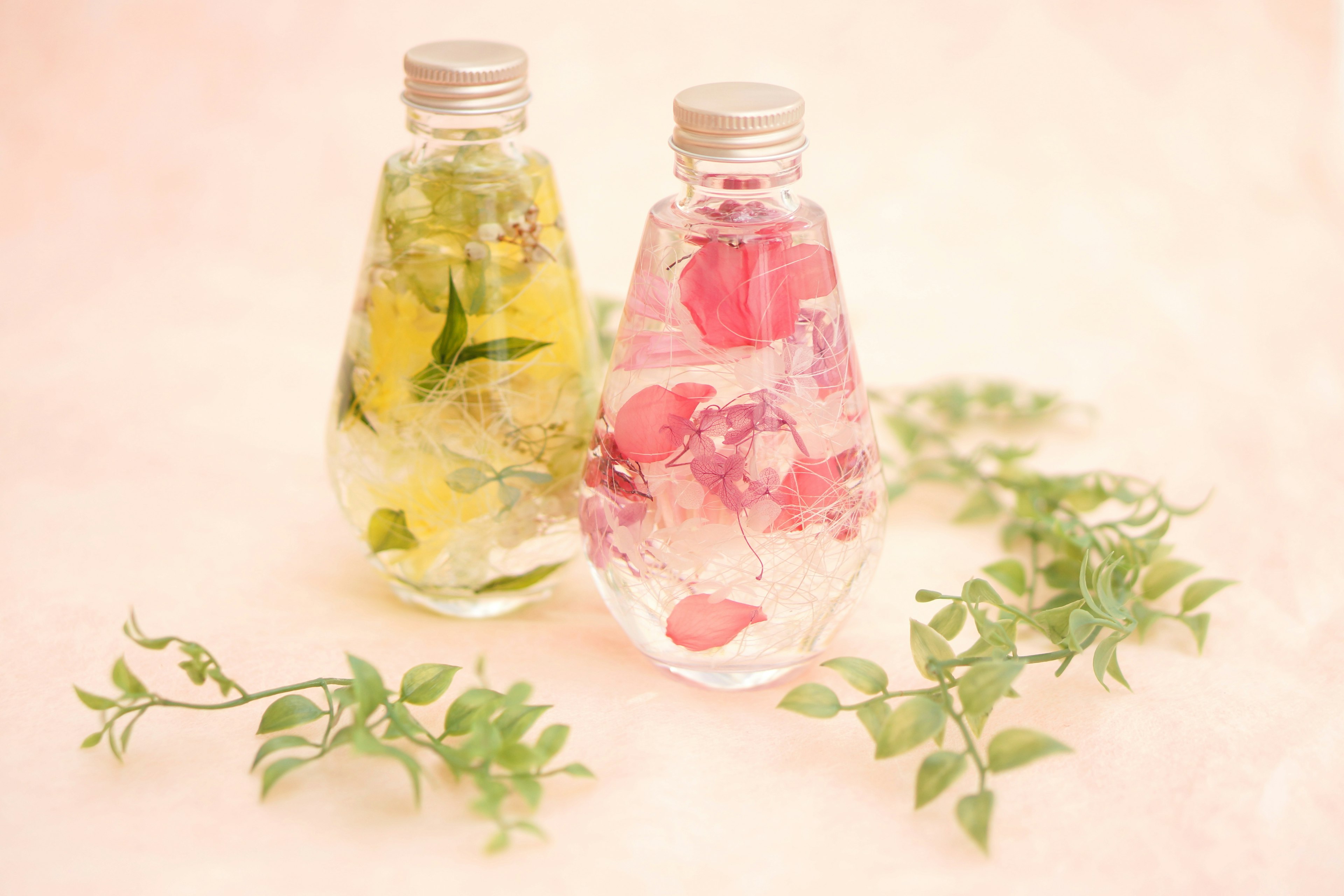 Infused water in clear bottles with flowers and herbs