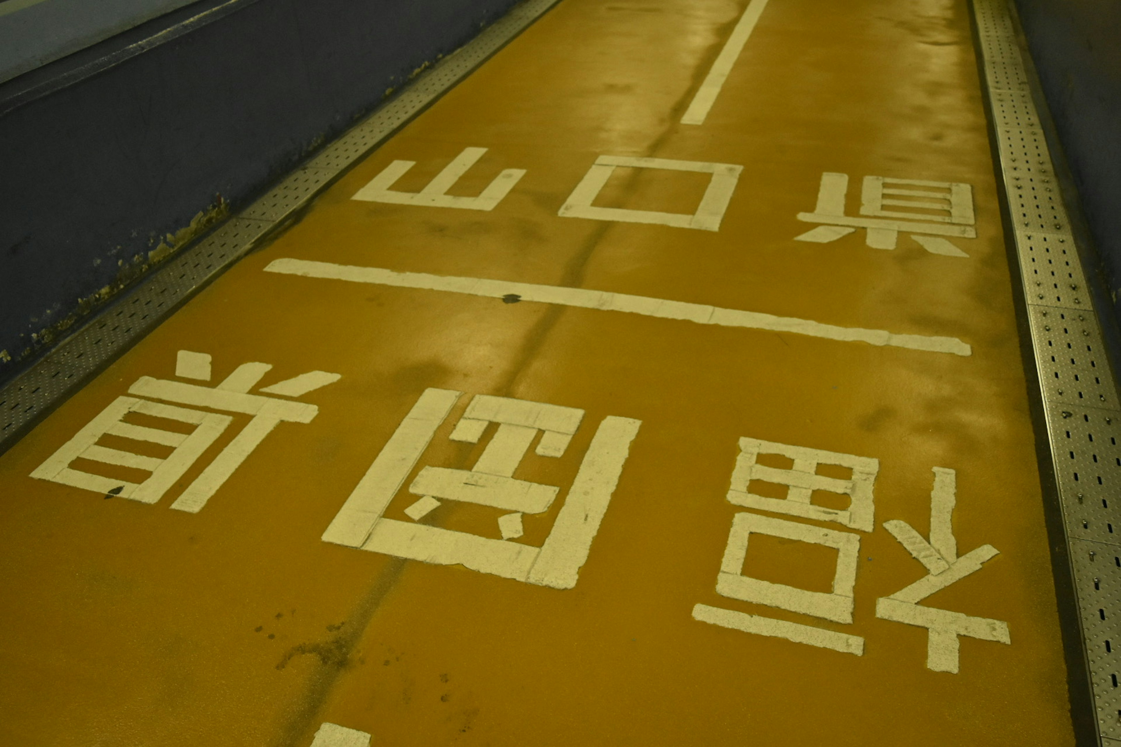 Strada gialla con testo bianco che indica la prefettura di Yamaguchi