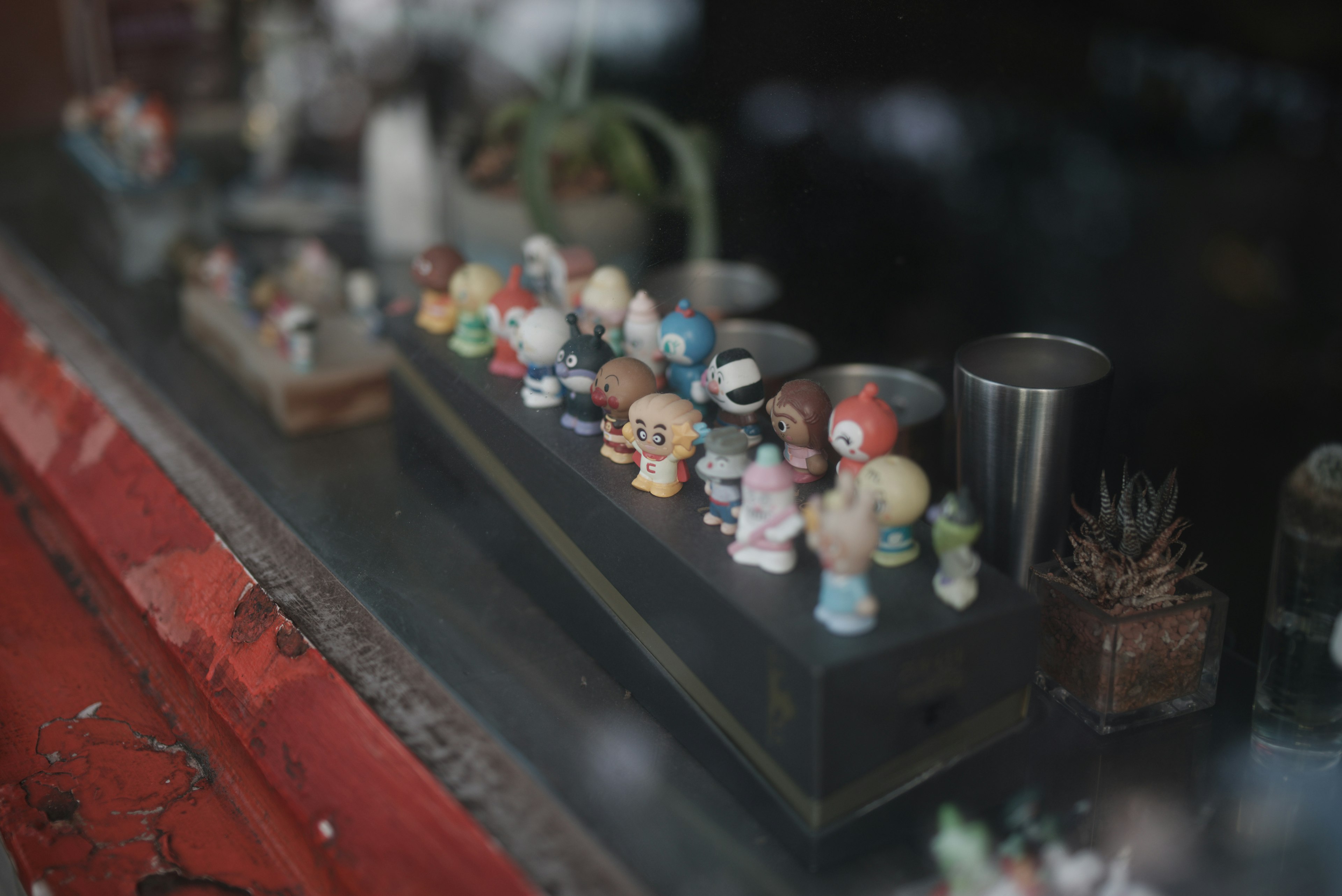 Figurines colorées en petits groupes dans une vitrine de magasin