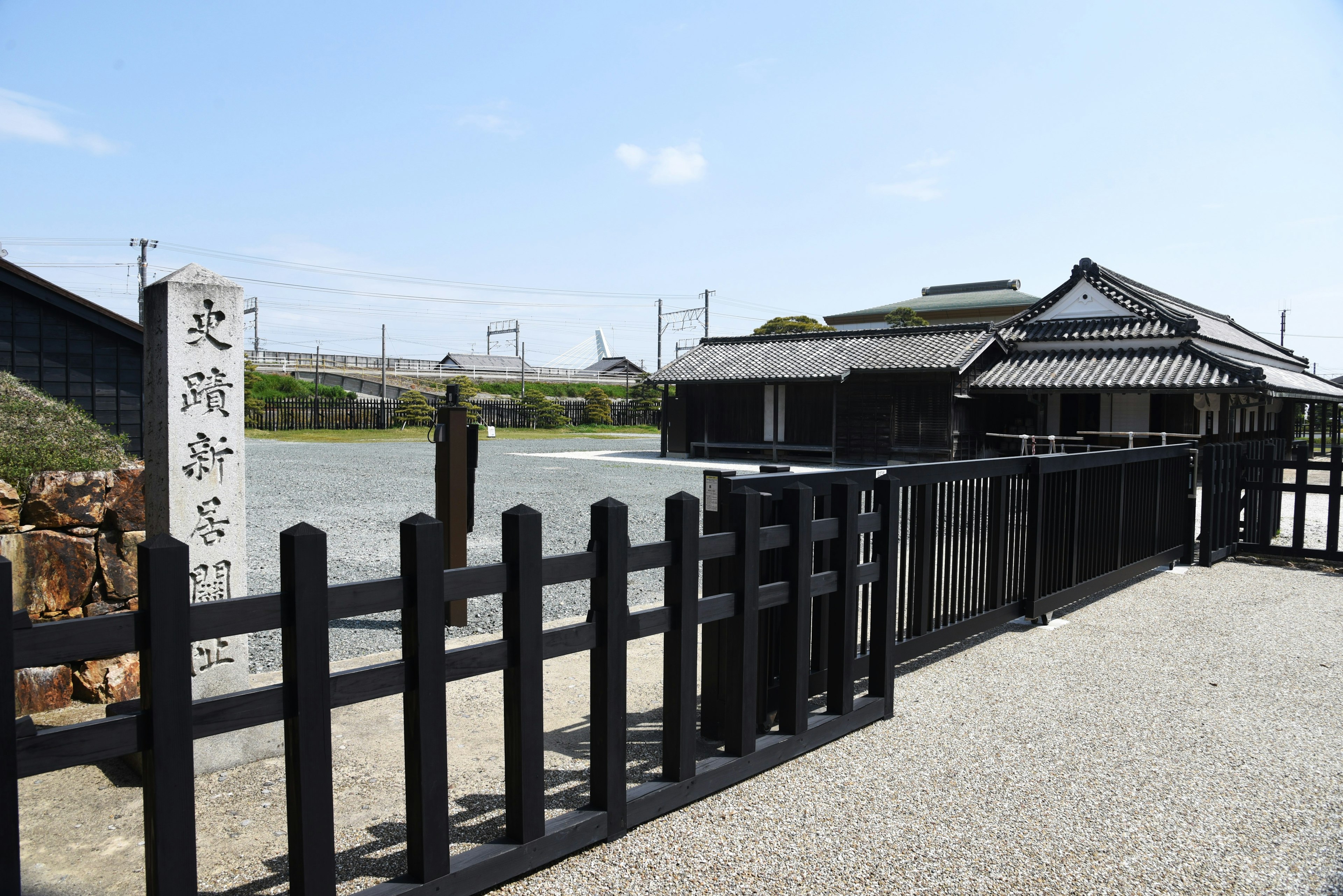 Casa japonesa tradicional con cerca negra y fondo escénico