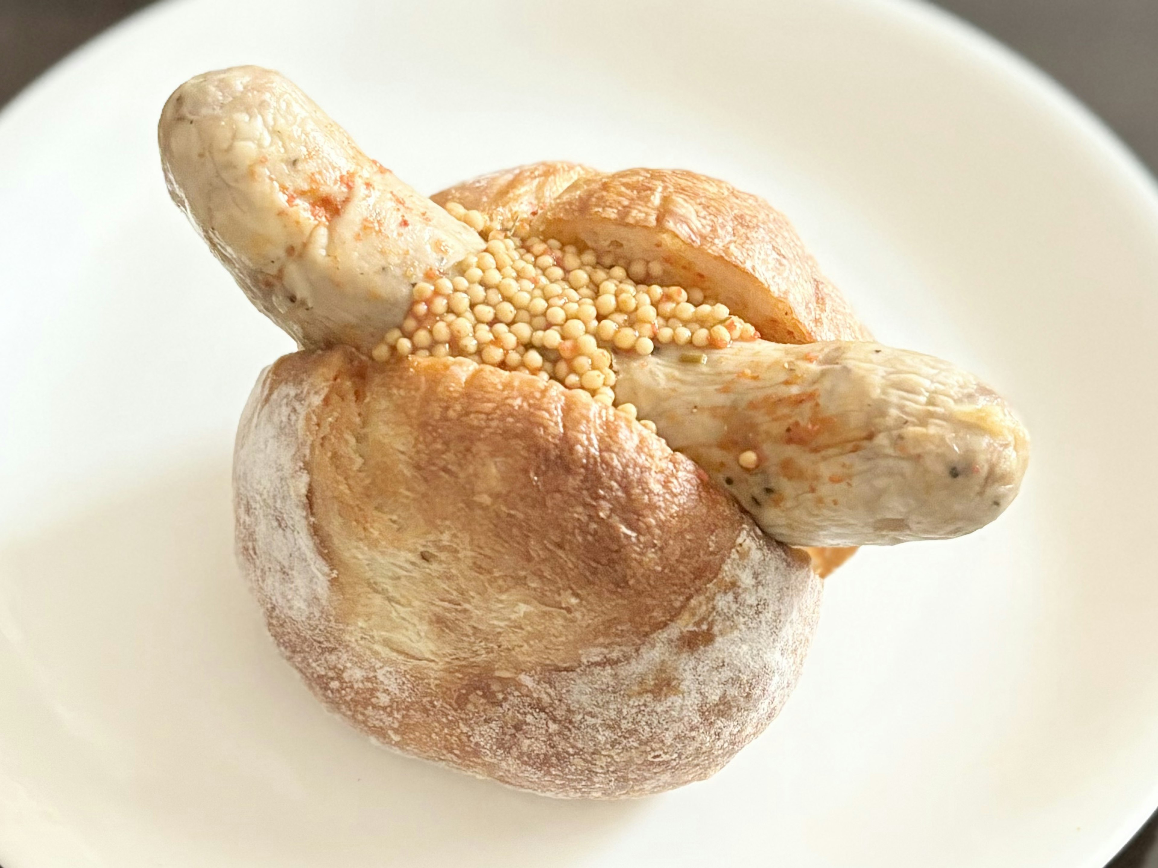 Unique round bread topped with mustard seeds and shaped like a small bundle