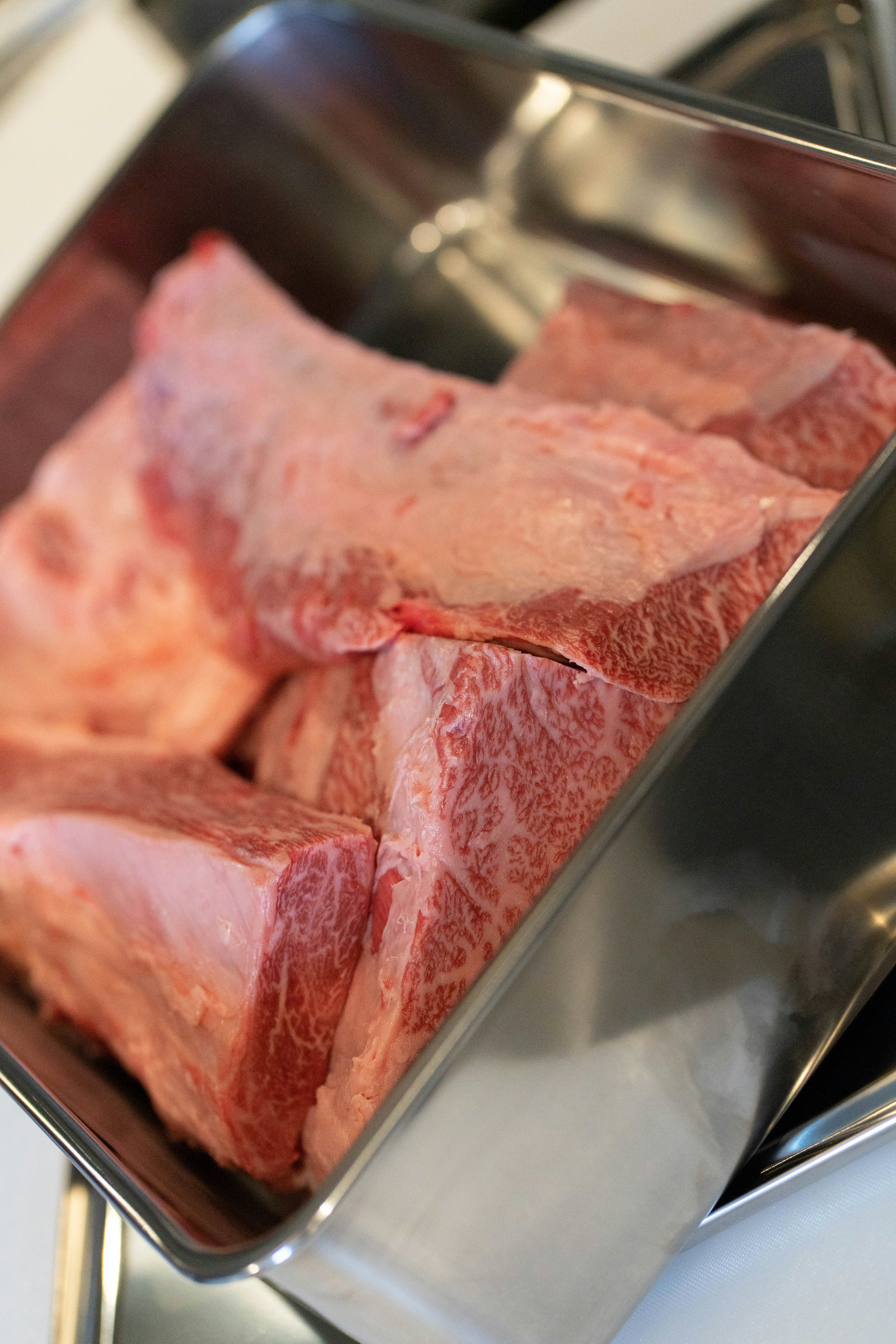 Trozos de carne cruda en una olla de acero inoxidable