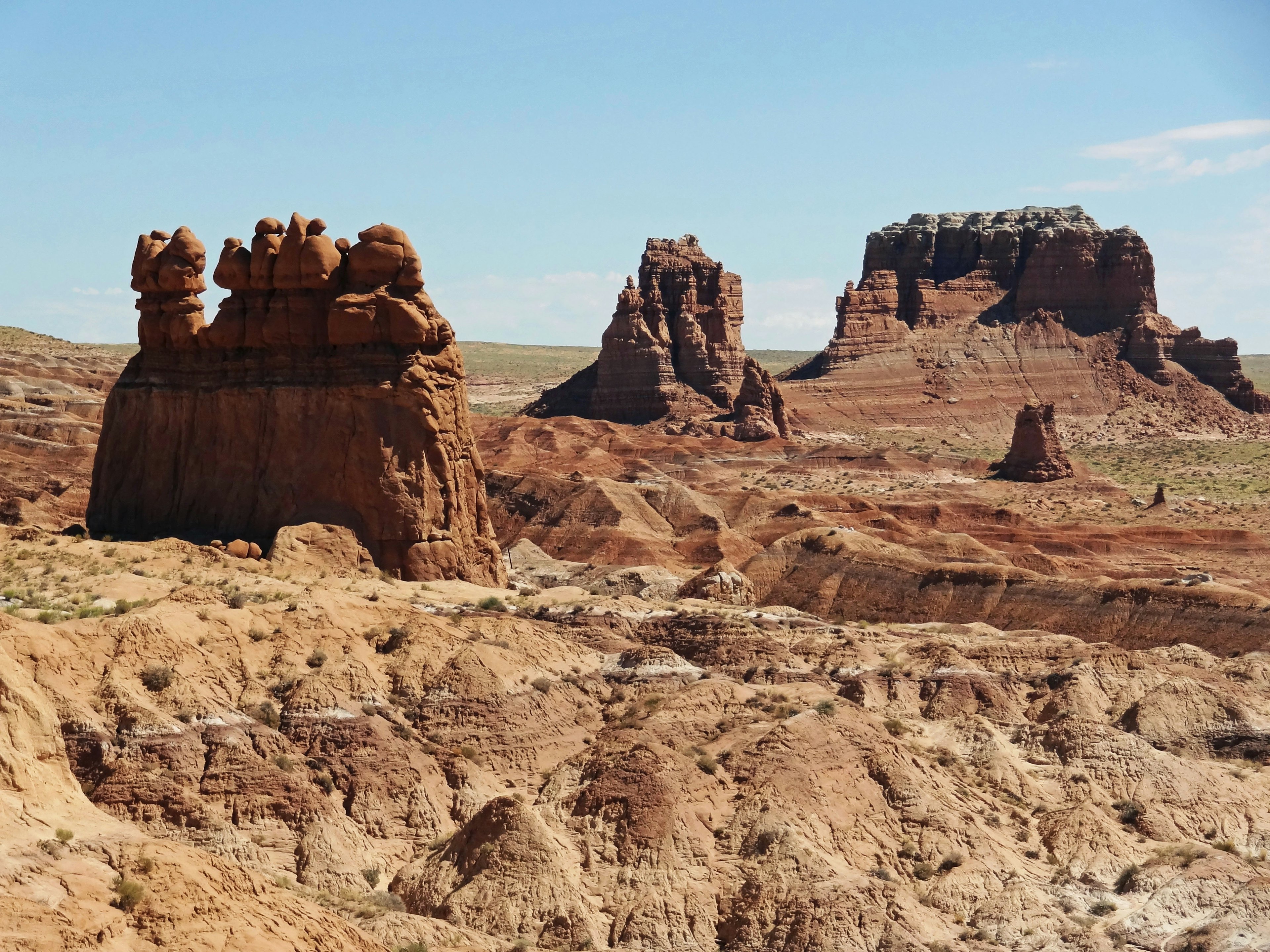 Vista panoramica di formazioni rocciose rosse con forme uniche e mesas lontane