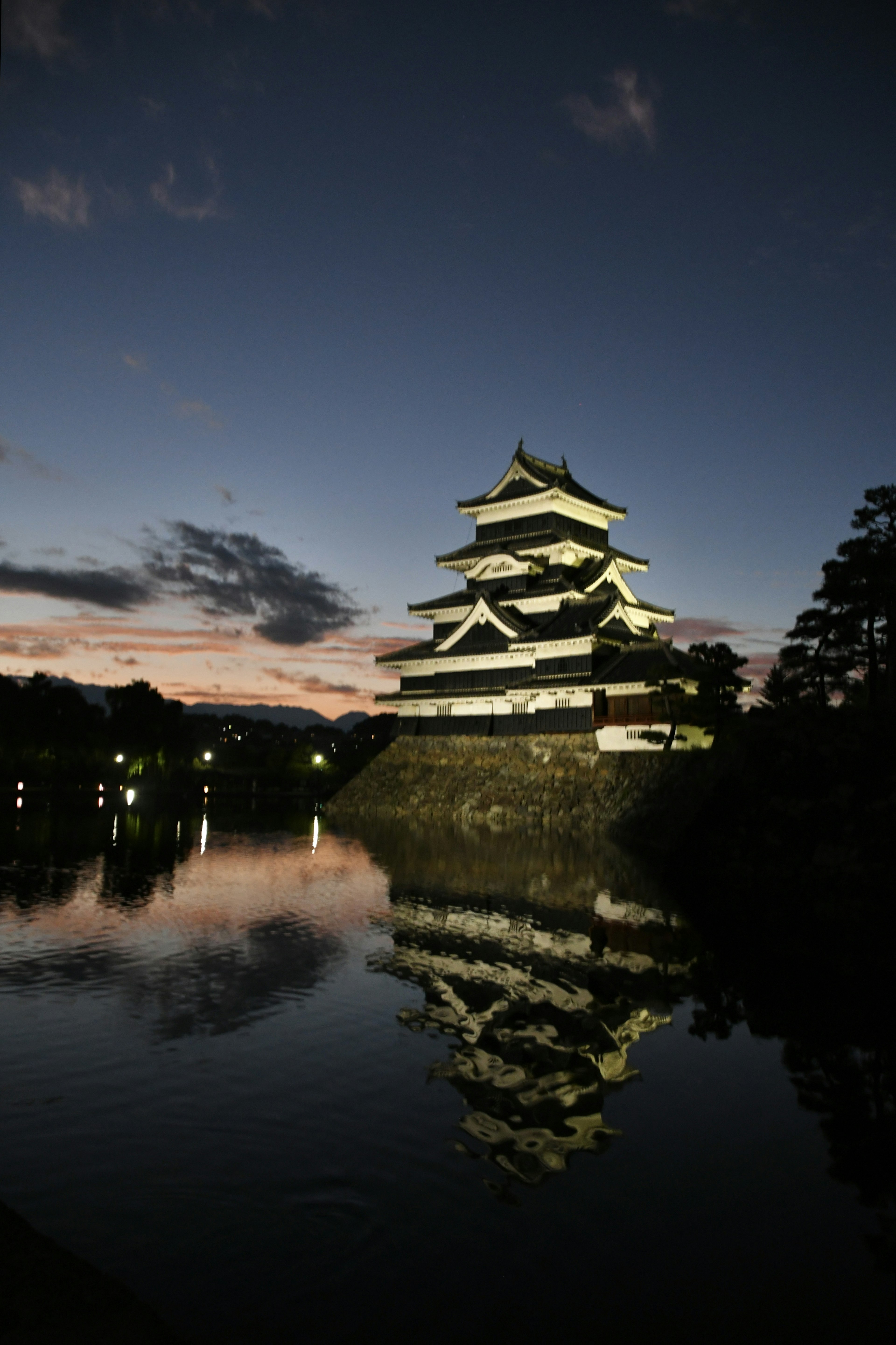 Matsumoto Schloss bei Nacht beleuchtet mit Reflexion im Wasser