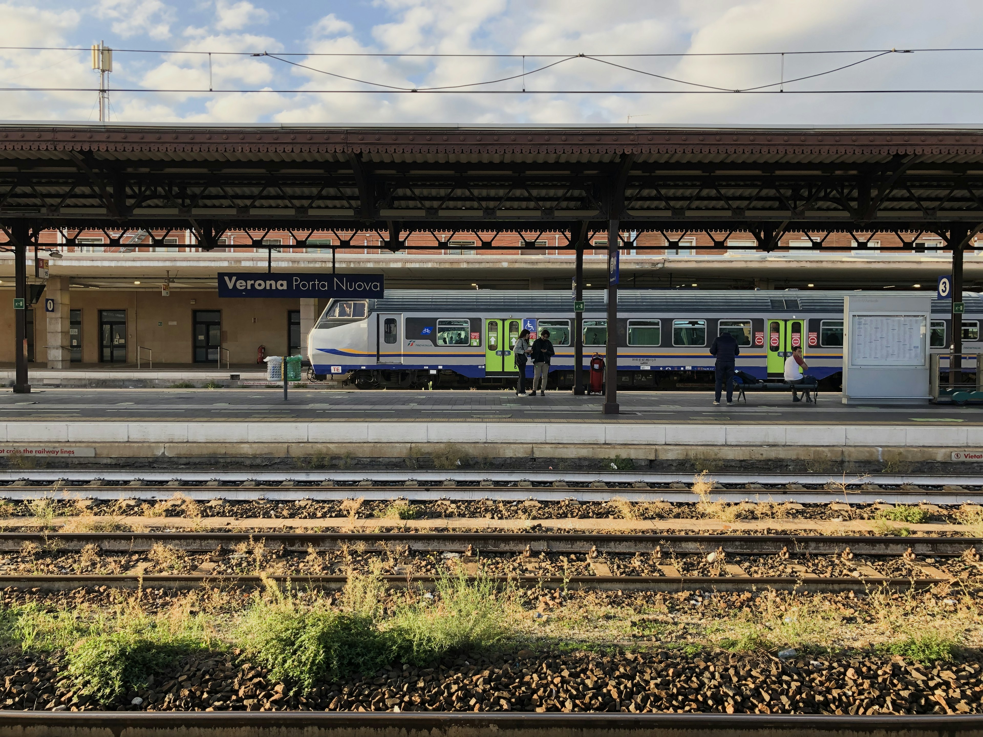 Vue d'un train sur le quai avec un bâtiment de gare