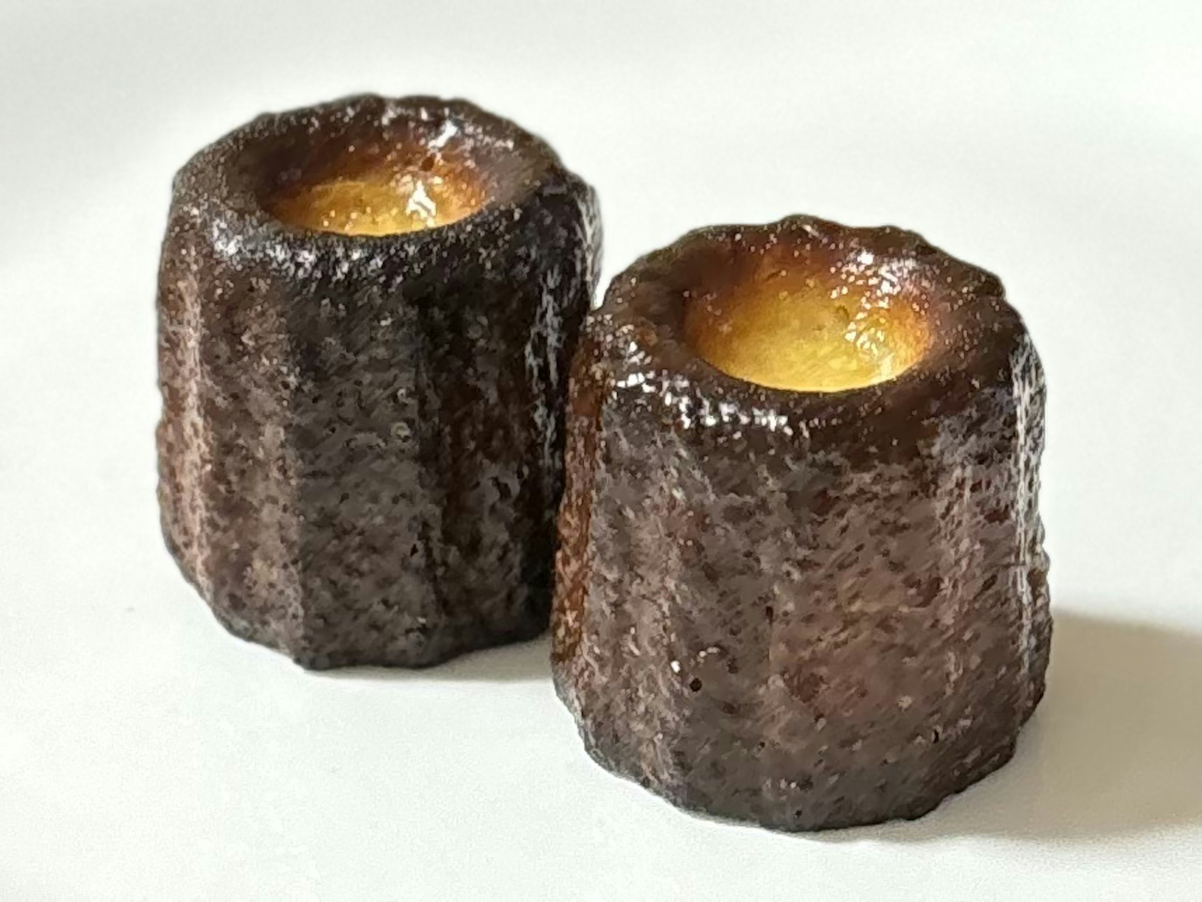 Zwei Cannelés auf einem weißen Teller