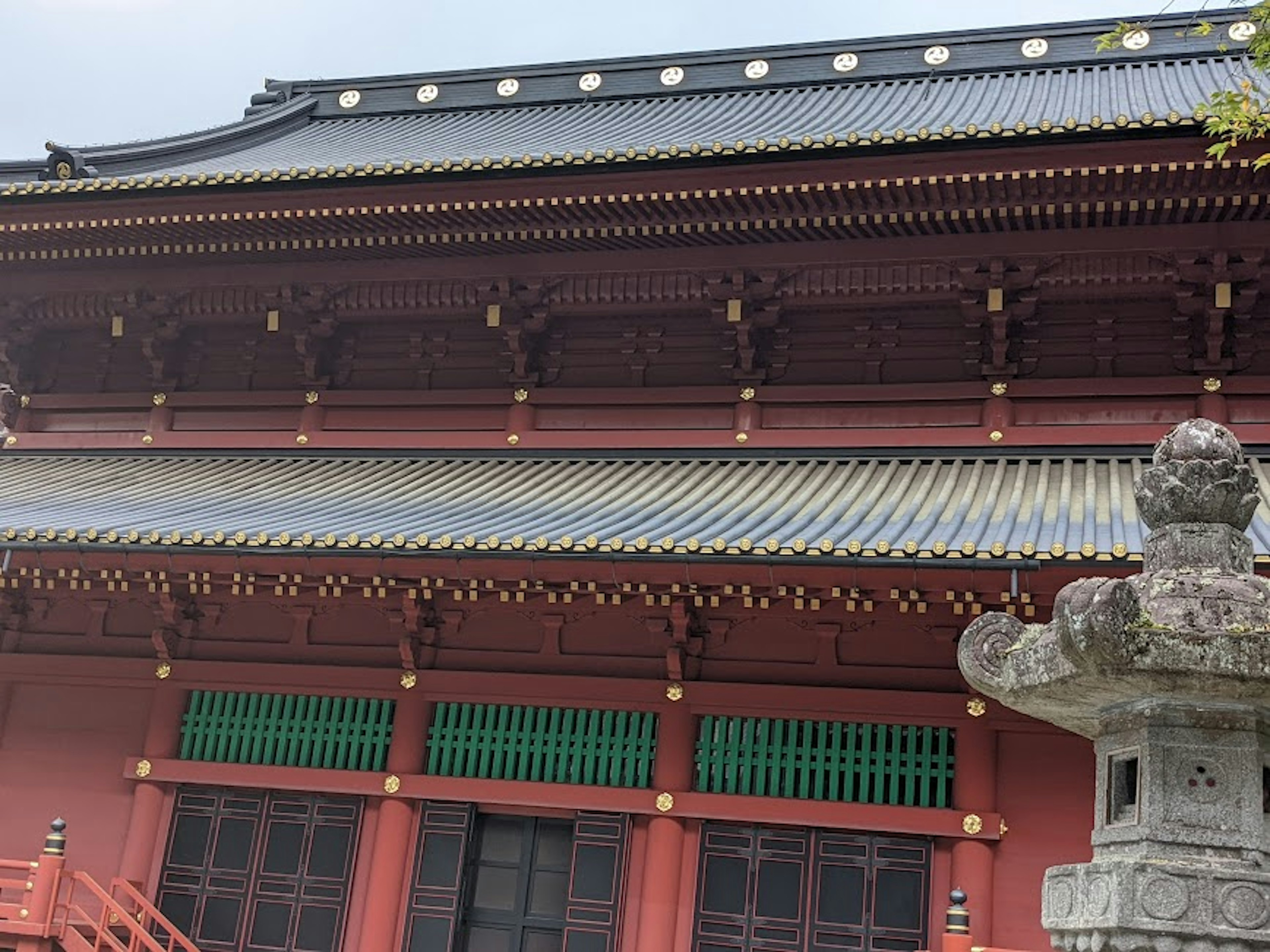 Traditional building with red walls and green windows featuring ornate roof