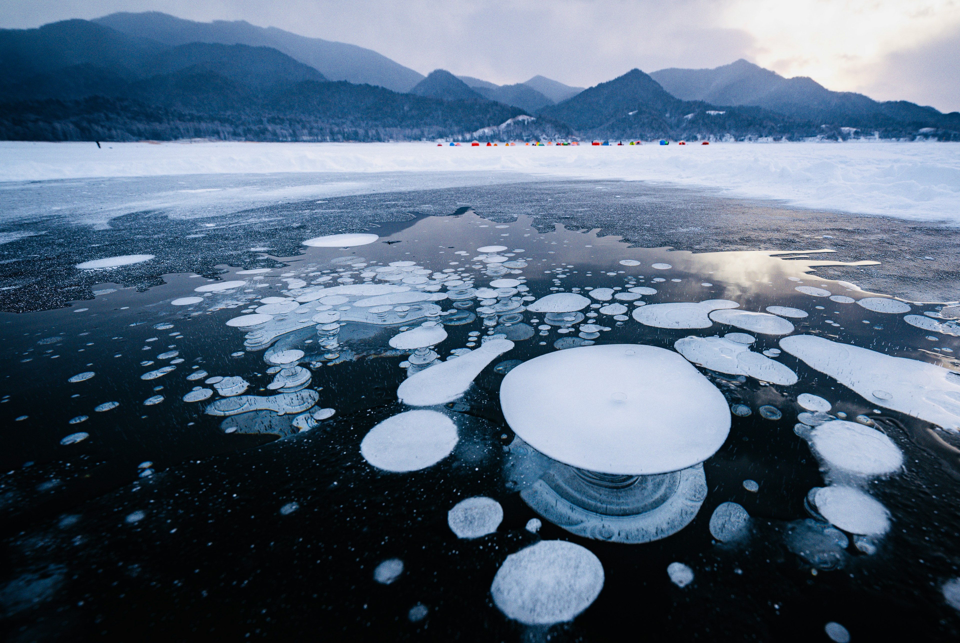 冰面上漂浮的白色气泡与山景