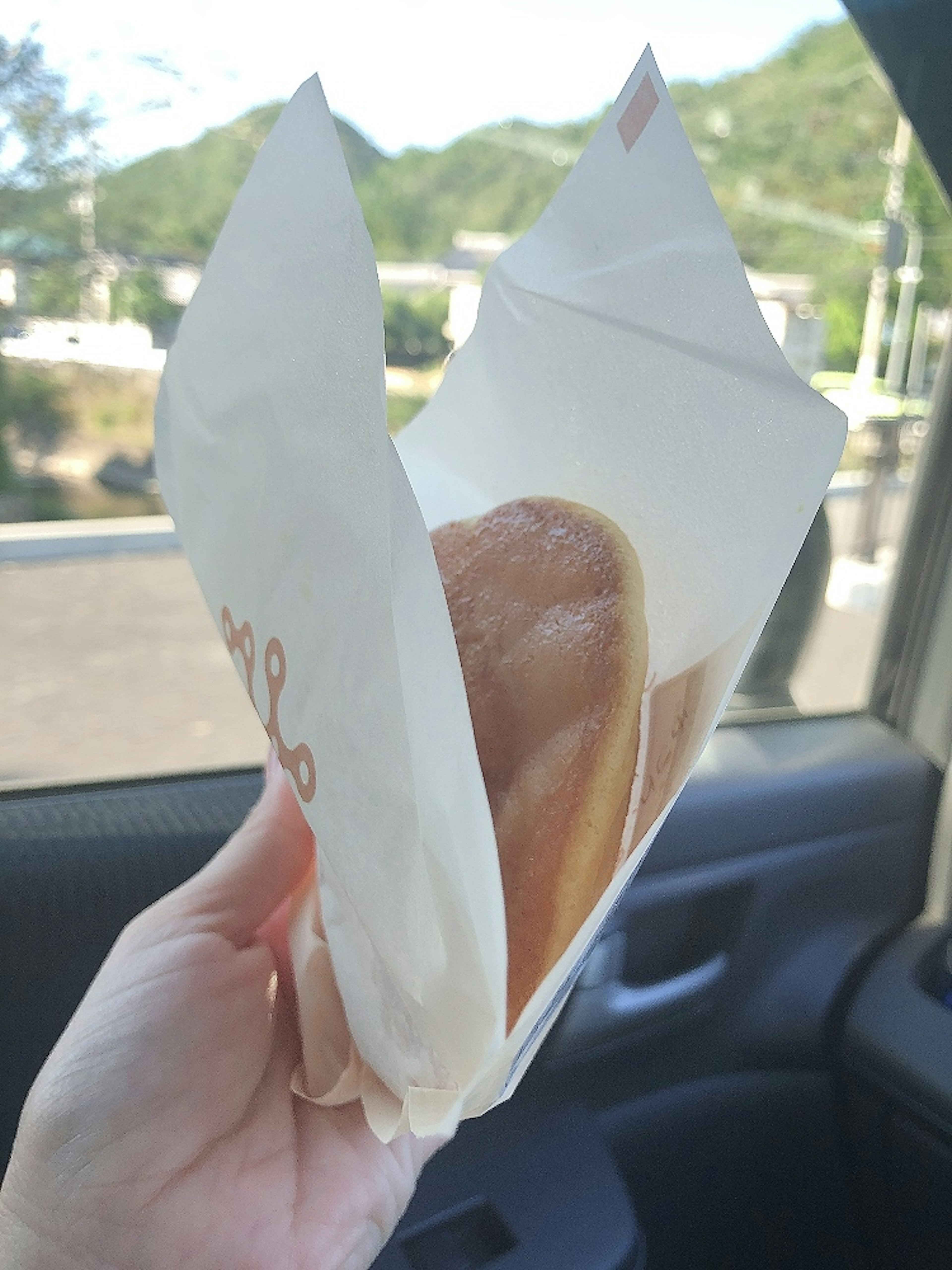 Foto di un panino dolce in una busta di carta tenuta in mano