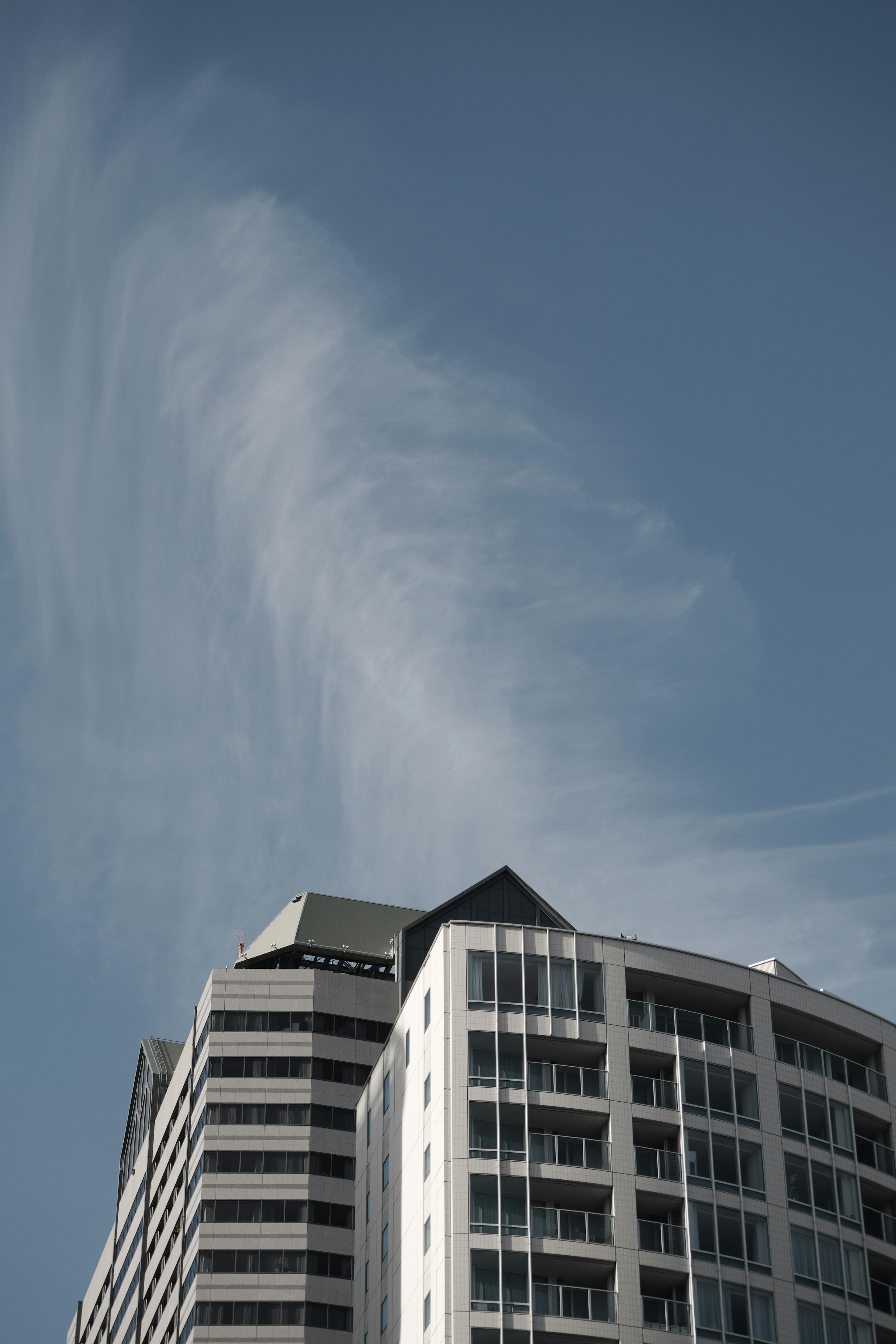 Edificio moderno contro un cielo blu chiaro con nuvole sottili