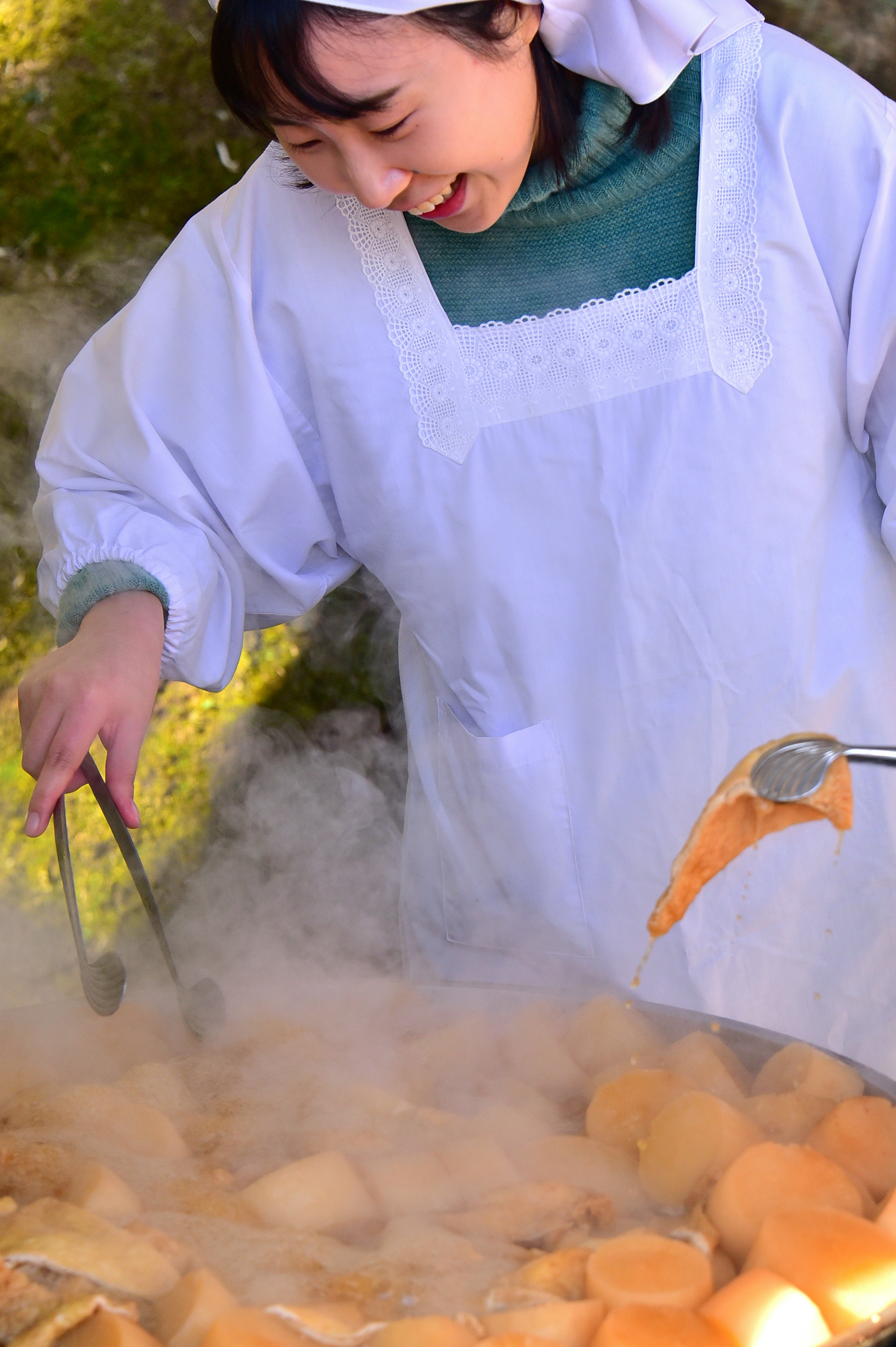 Frau kocht Zutaten in einem dampfenden Topf