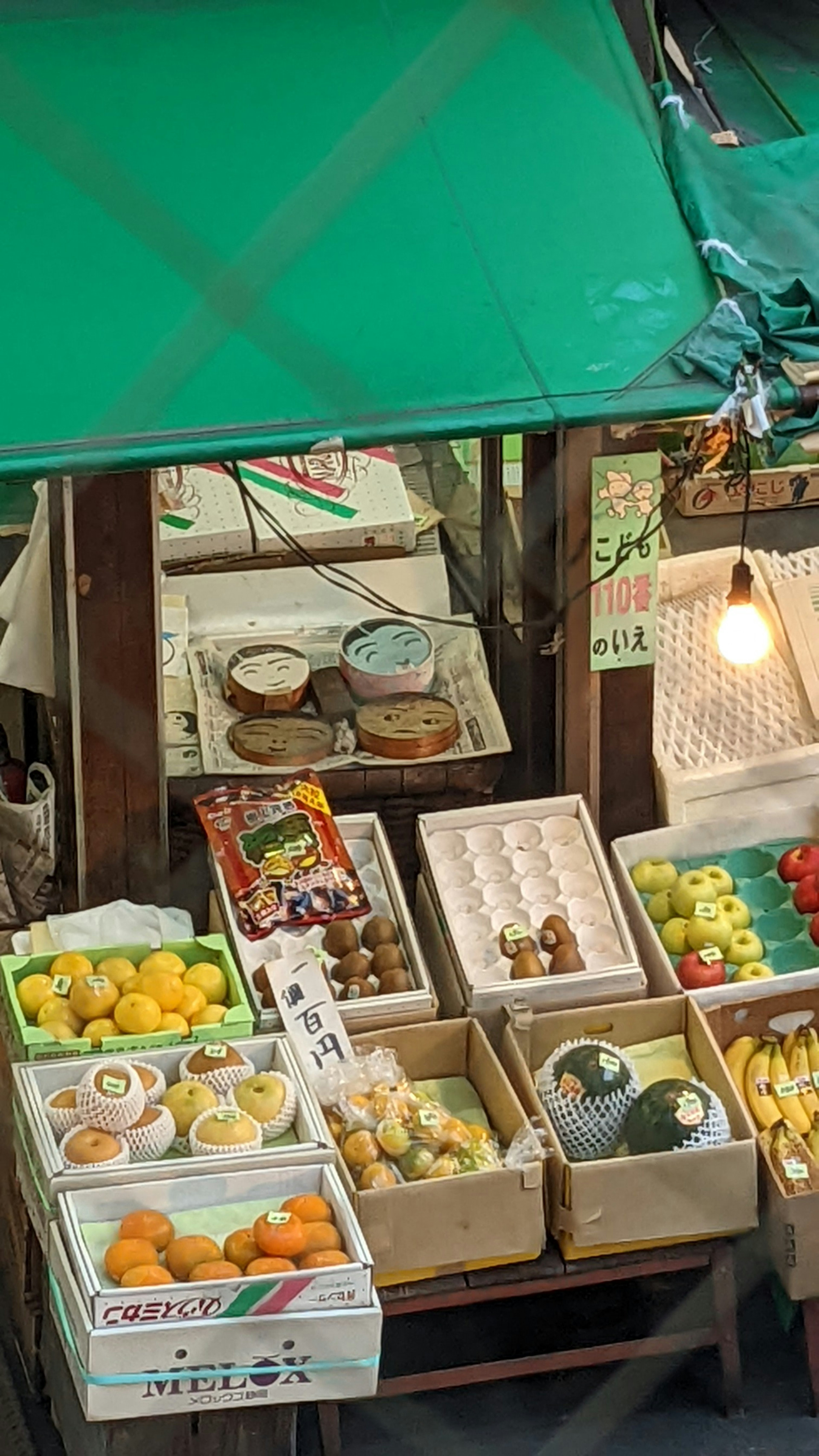 青い屋根の下に並ぶ新鮮な果物と野菜の市場の風景