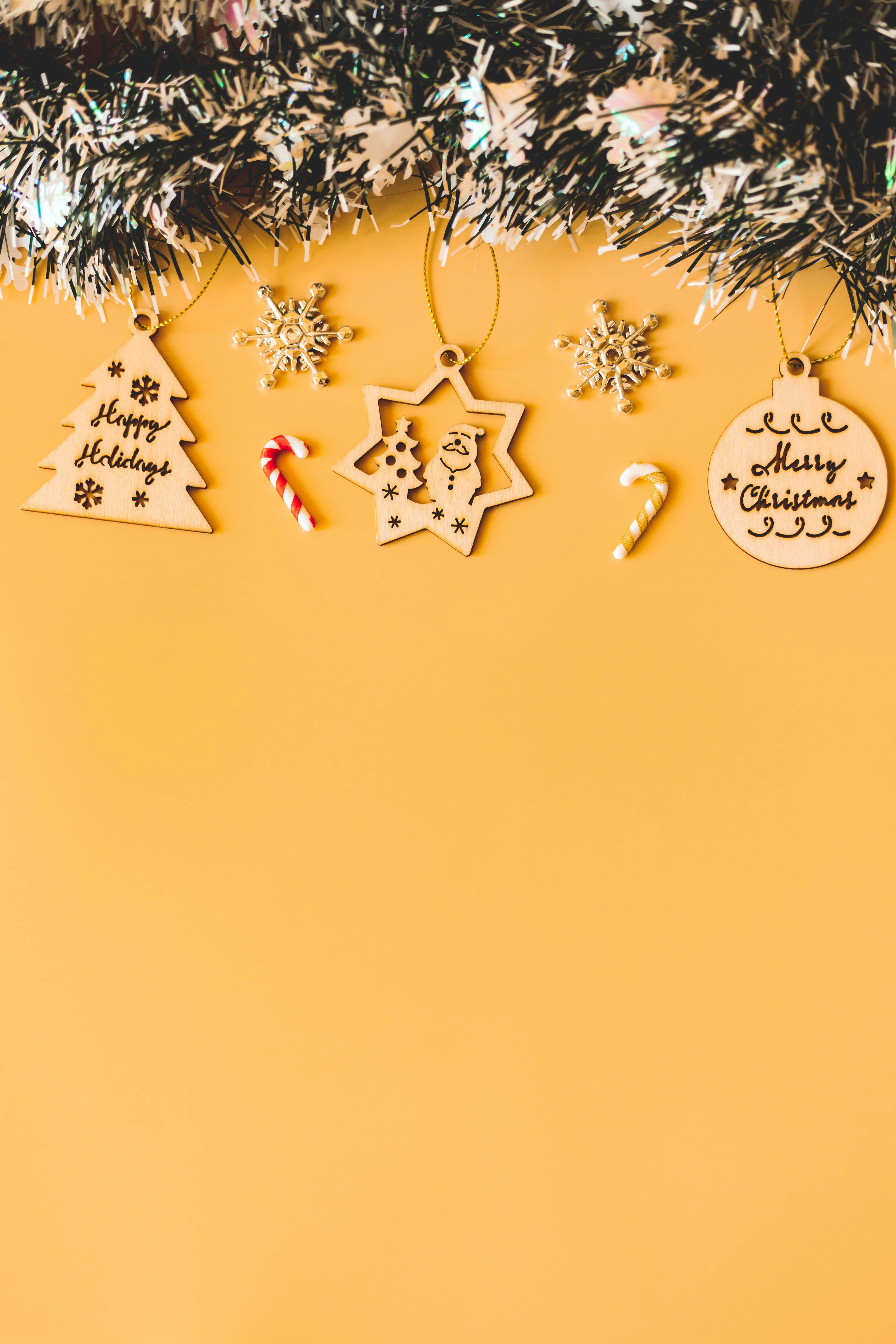 Bright yellow background with Christmas decorations and garland hanging