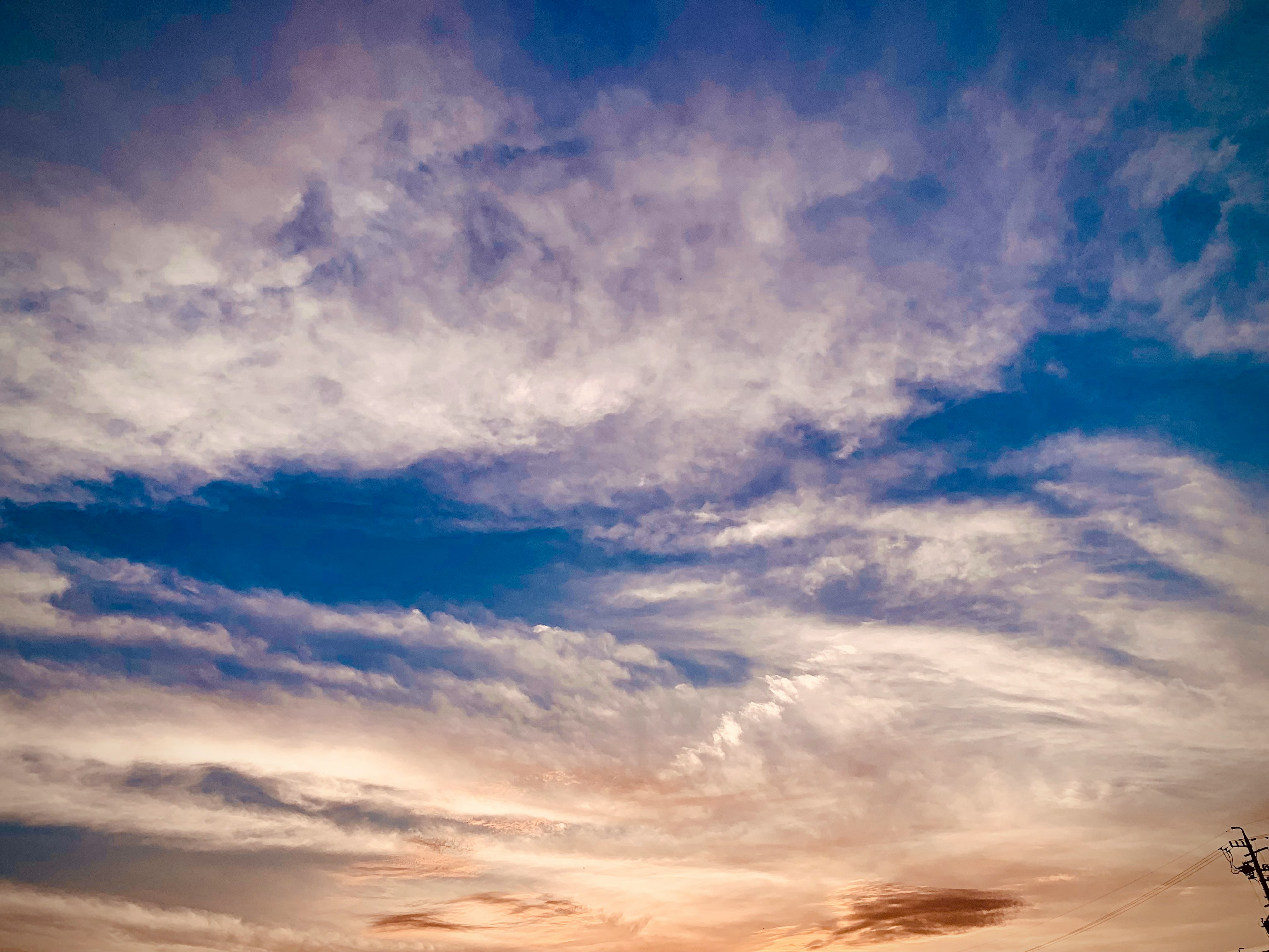 Amplio cielo azul con nubes finas durante el atardecer