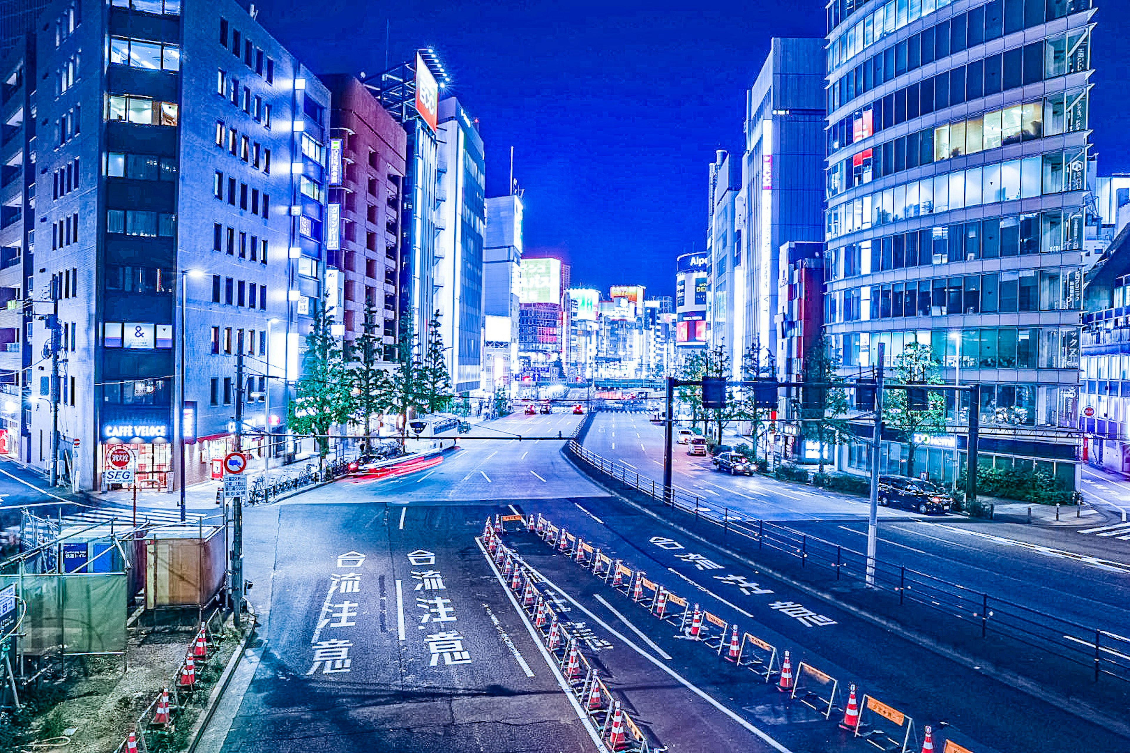 夜の都市風景が広がる交差点の画像 高層ビルが立ち並び ネオンライトが輝く