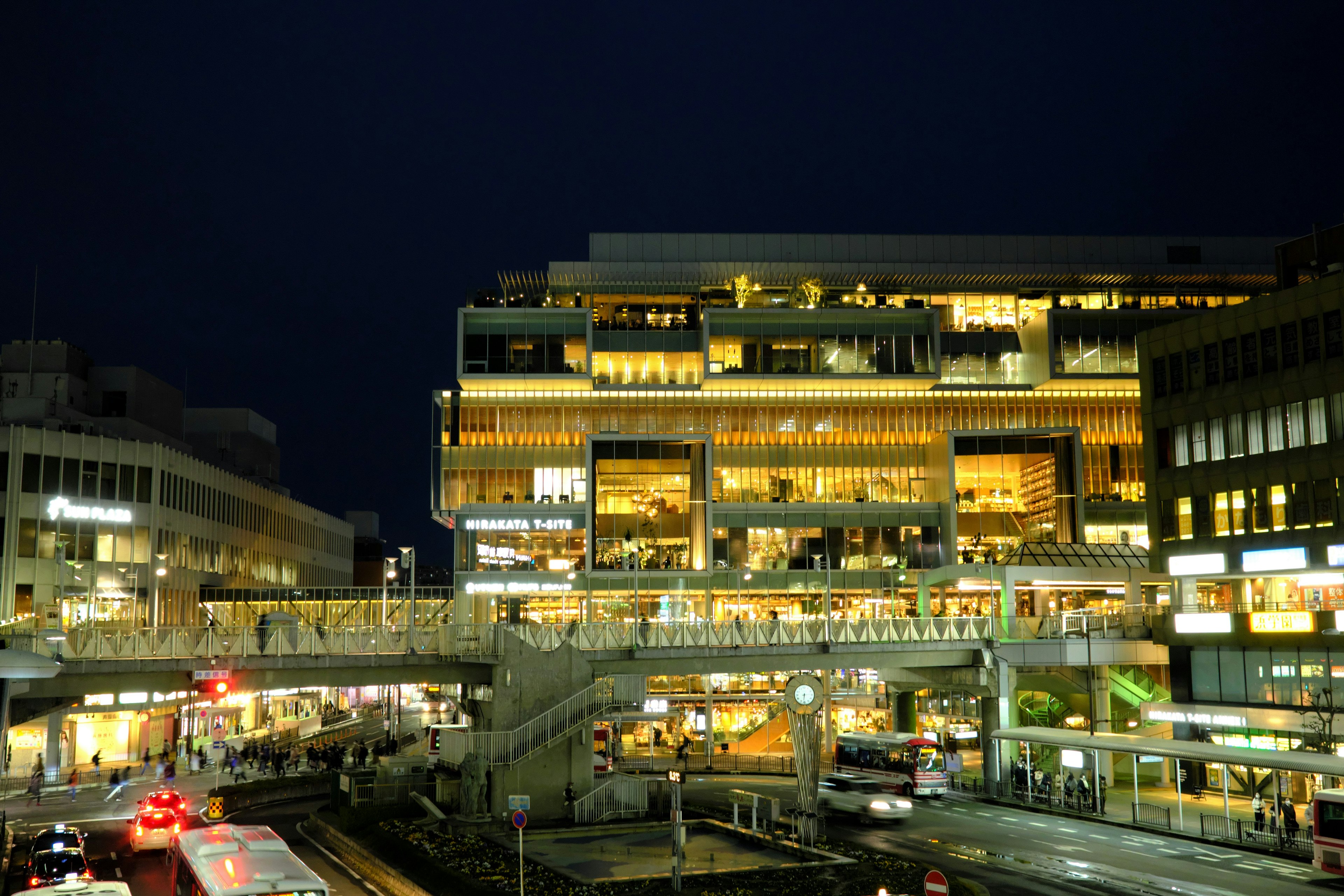 Helle Gebäude bei Nacht mit geschäftigem Stadtverkehr