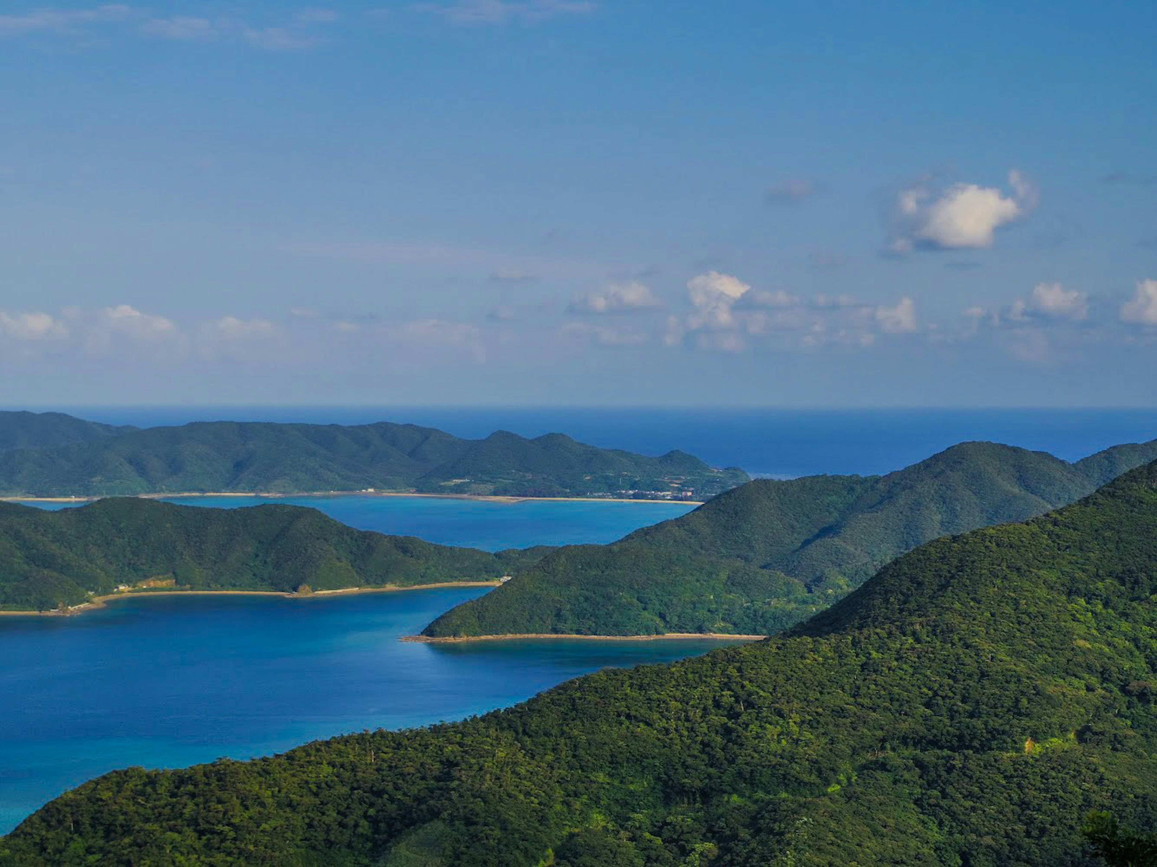 Vista escénica del océano azul y las montañas verdes