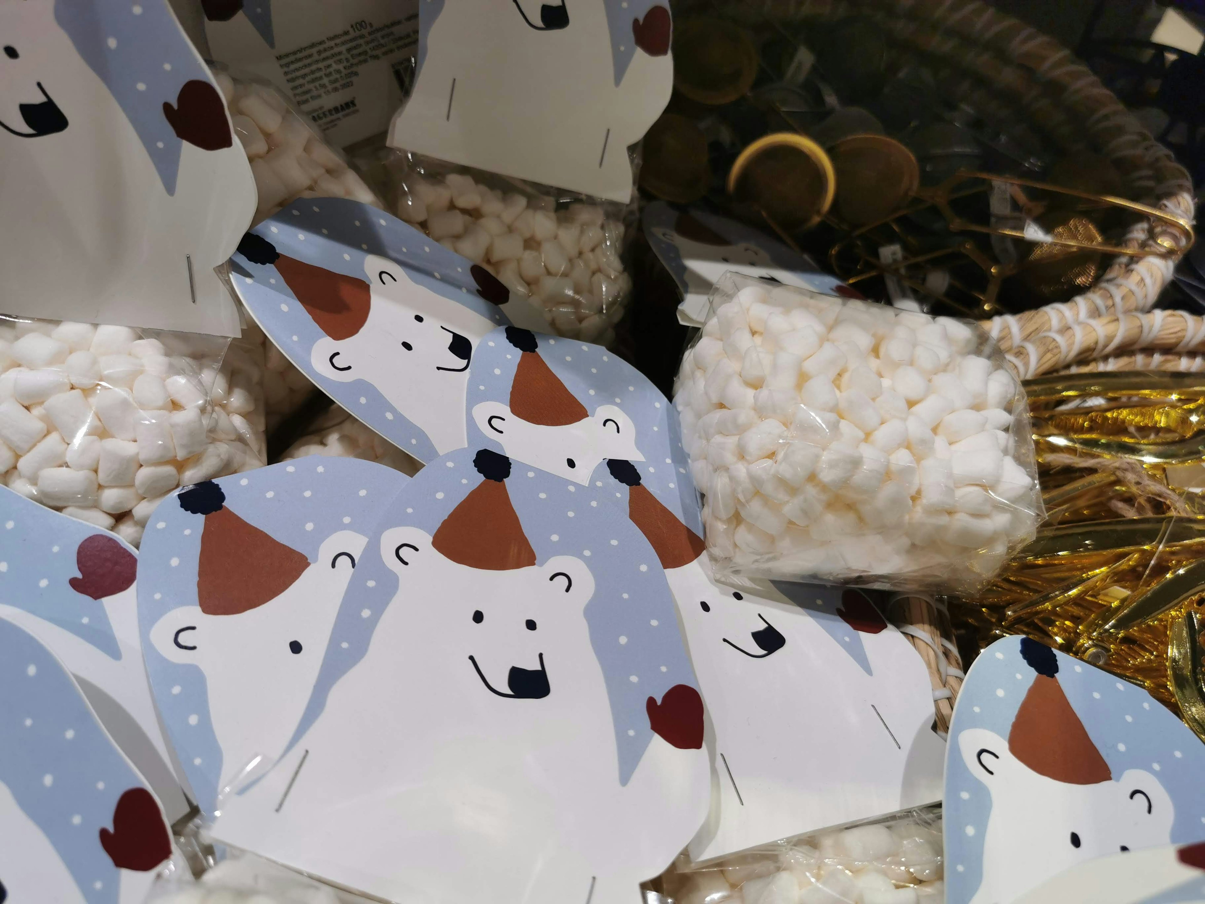 Illustrated polar bear cards scattered among white marshmallows and decorative items