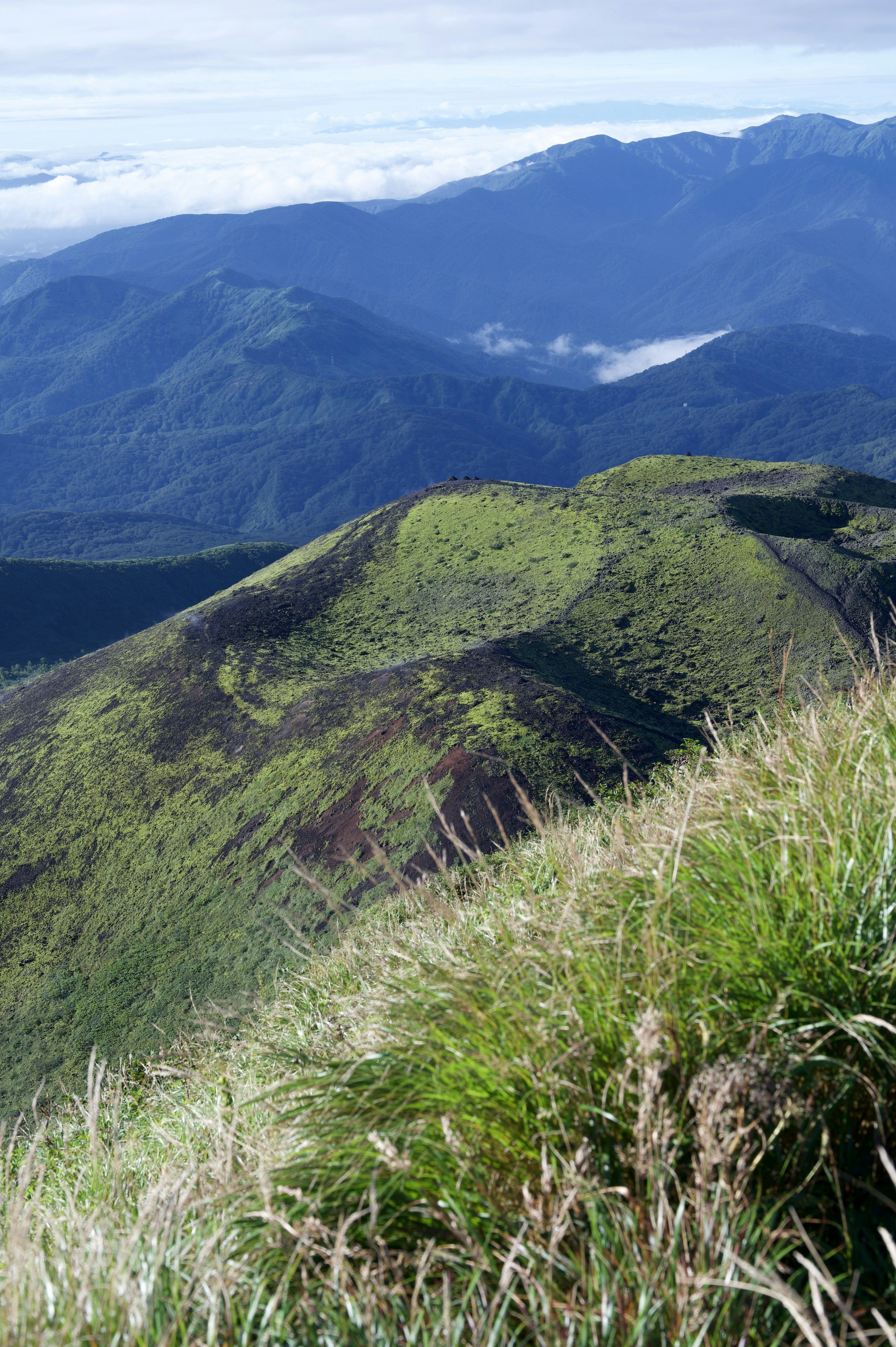 綠色山丘和遠處山脈的美麗景色