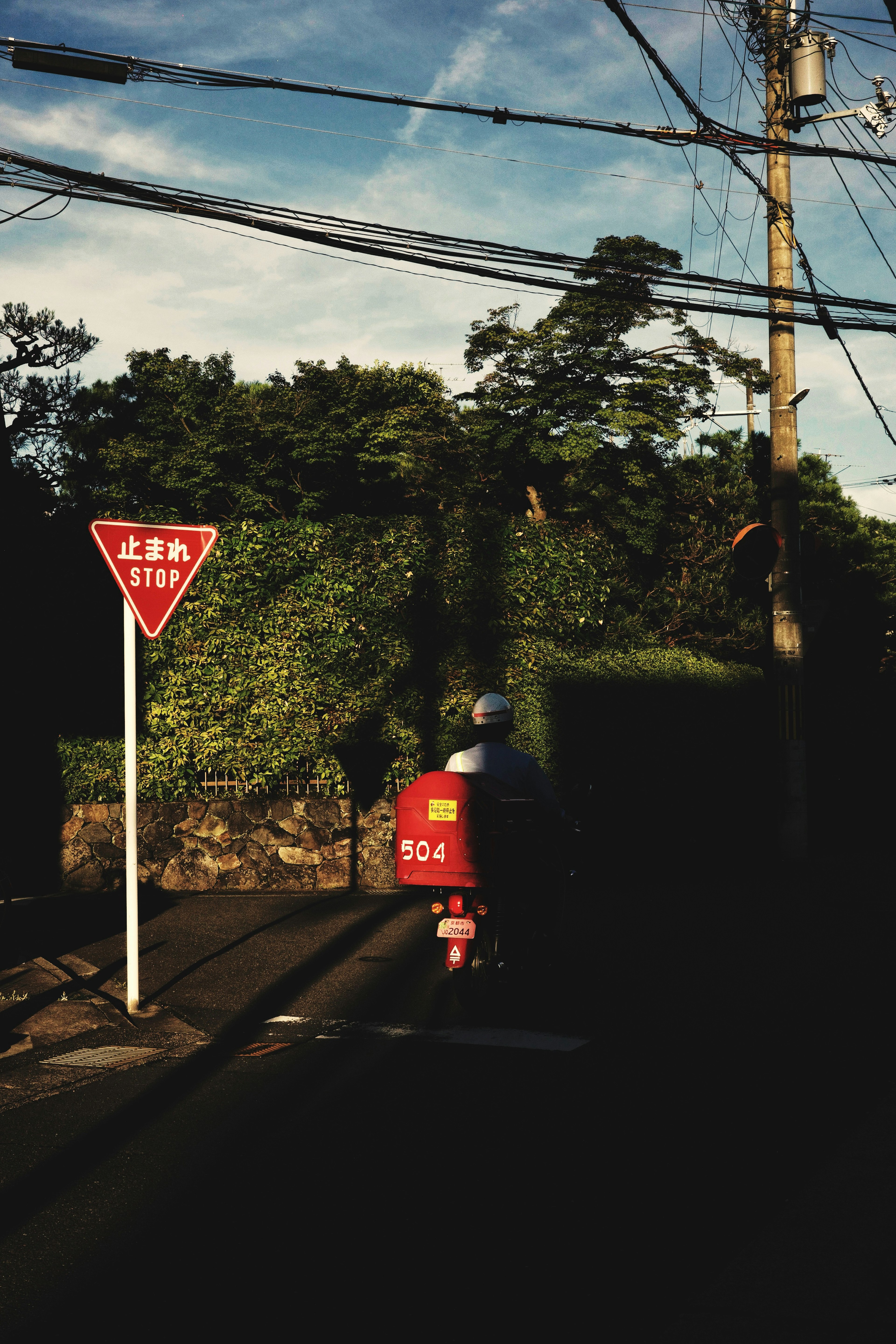 Ein rotes Motorrad, das an einer Kreuzung mit einem Vorfahrtsschild vorbeifährt