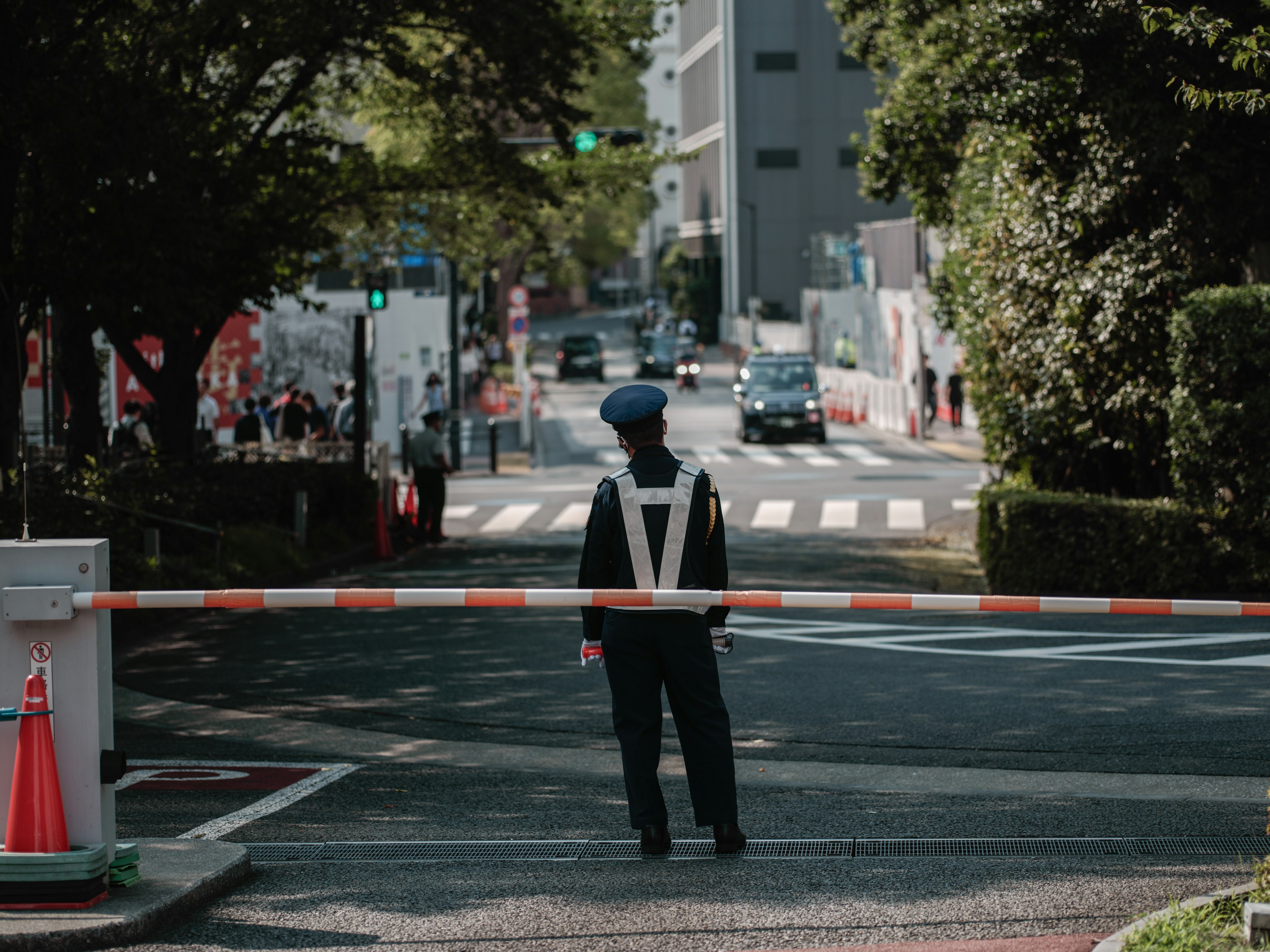 Un agent de sécurité surveillant la route avec une barrière contrôlant le flux de circulation