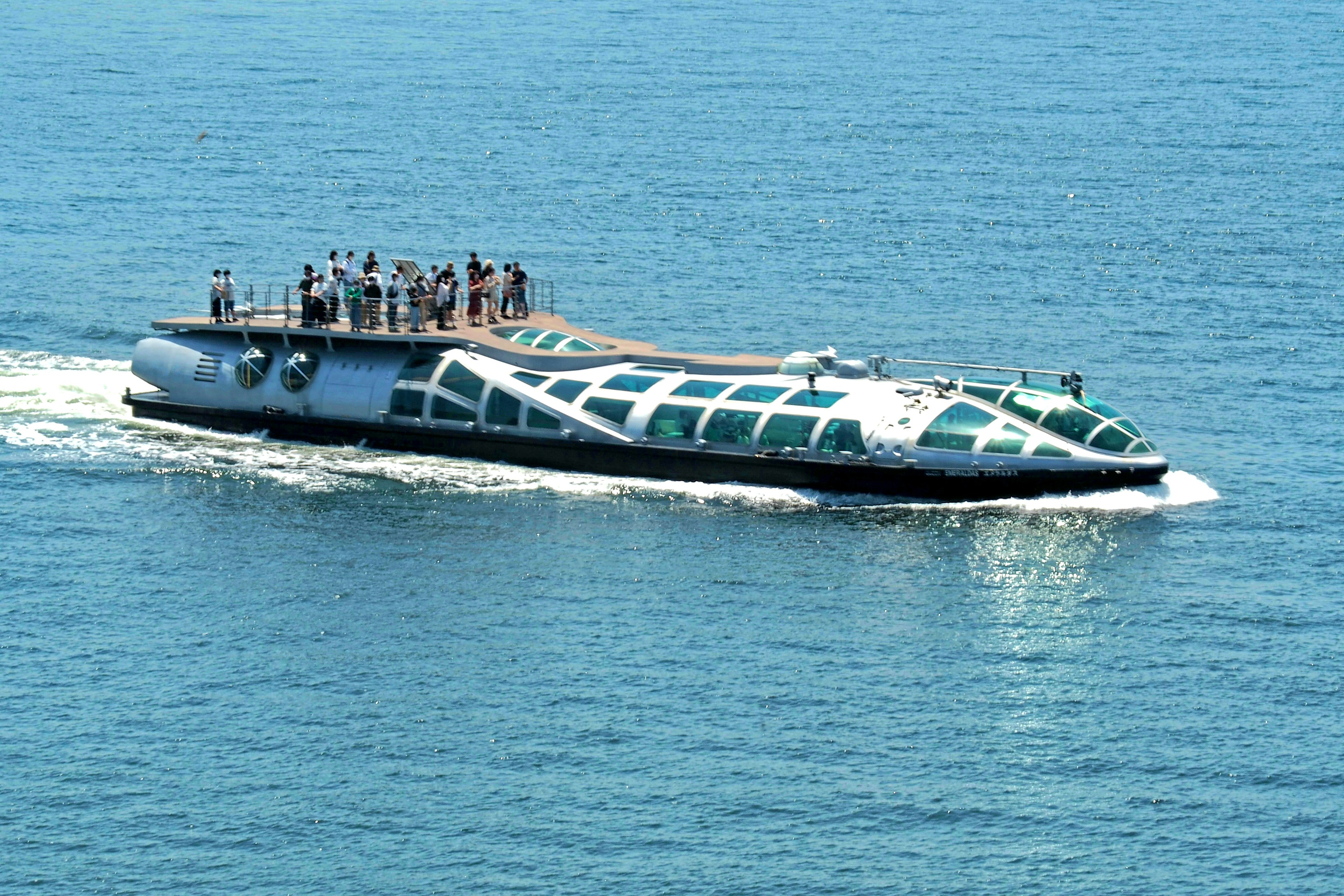 Barco de diseño único con pasajeros navegando en el mar