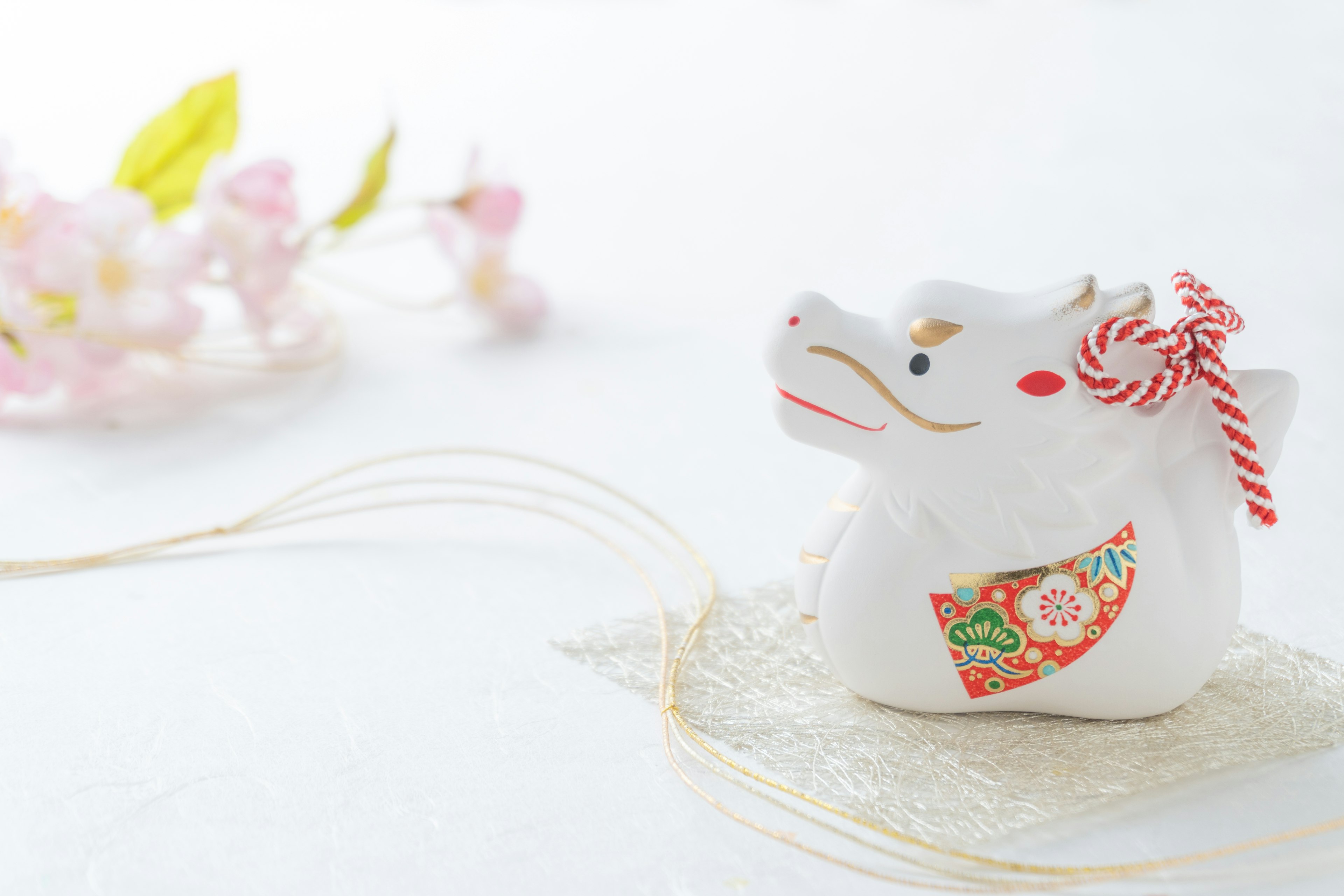 A white cow figurine placed next to flowers