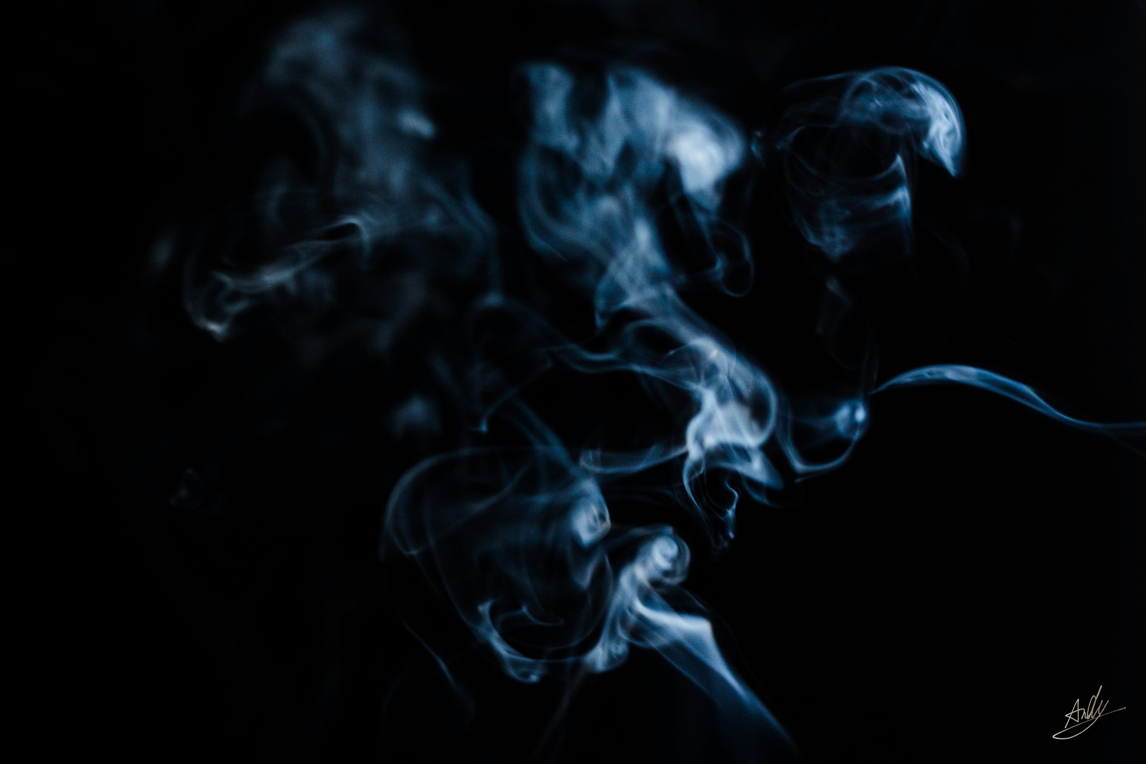 Abstract shapes of blue smoke on a black background