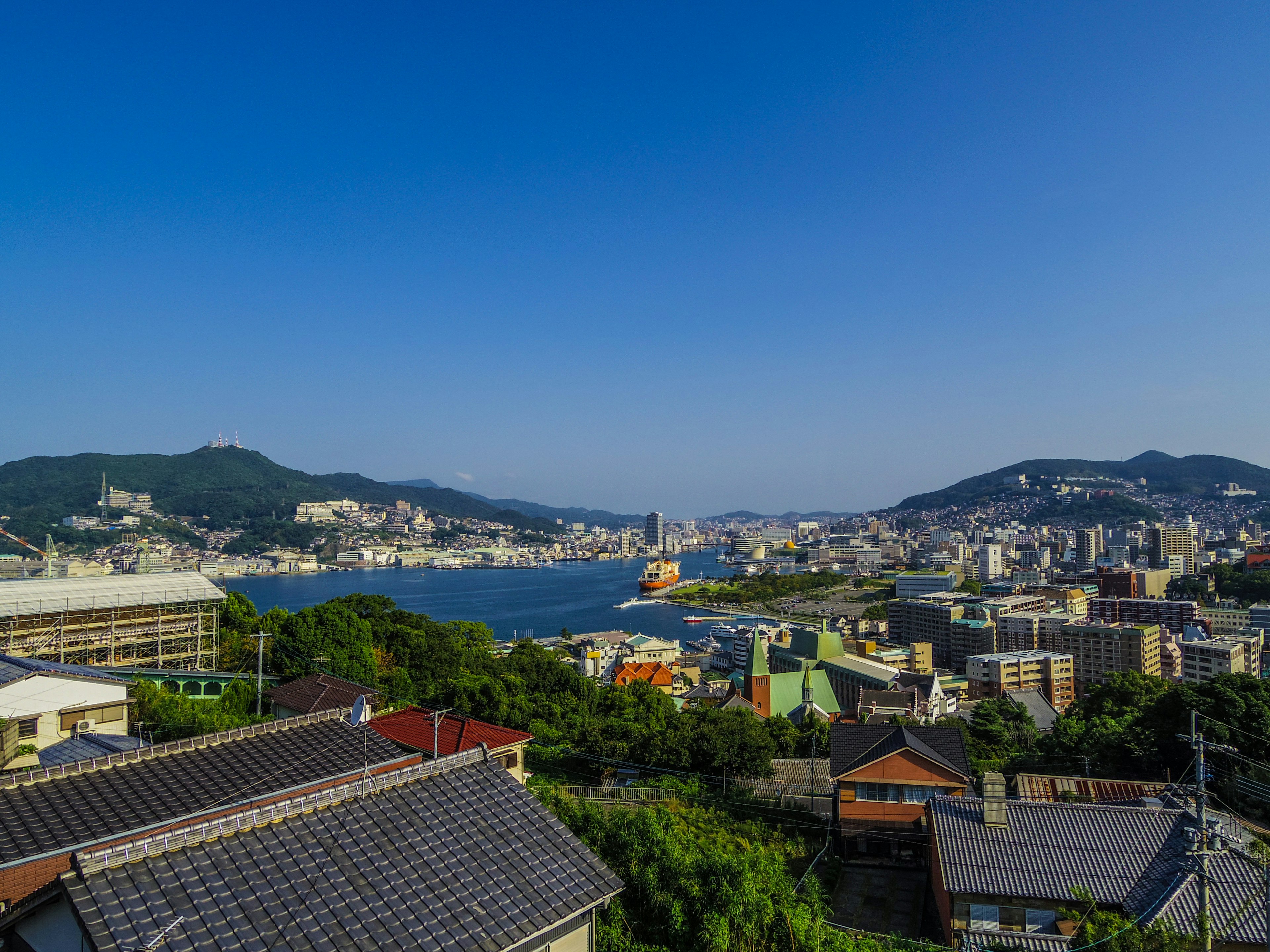 Panoramablick auf eine Küstenstadt mit blauem Himmel und Hügeln