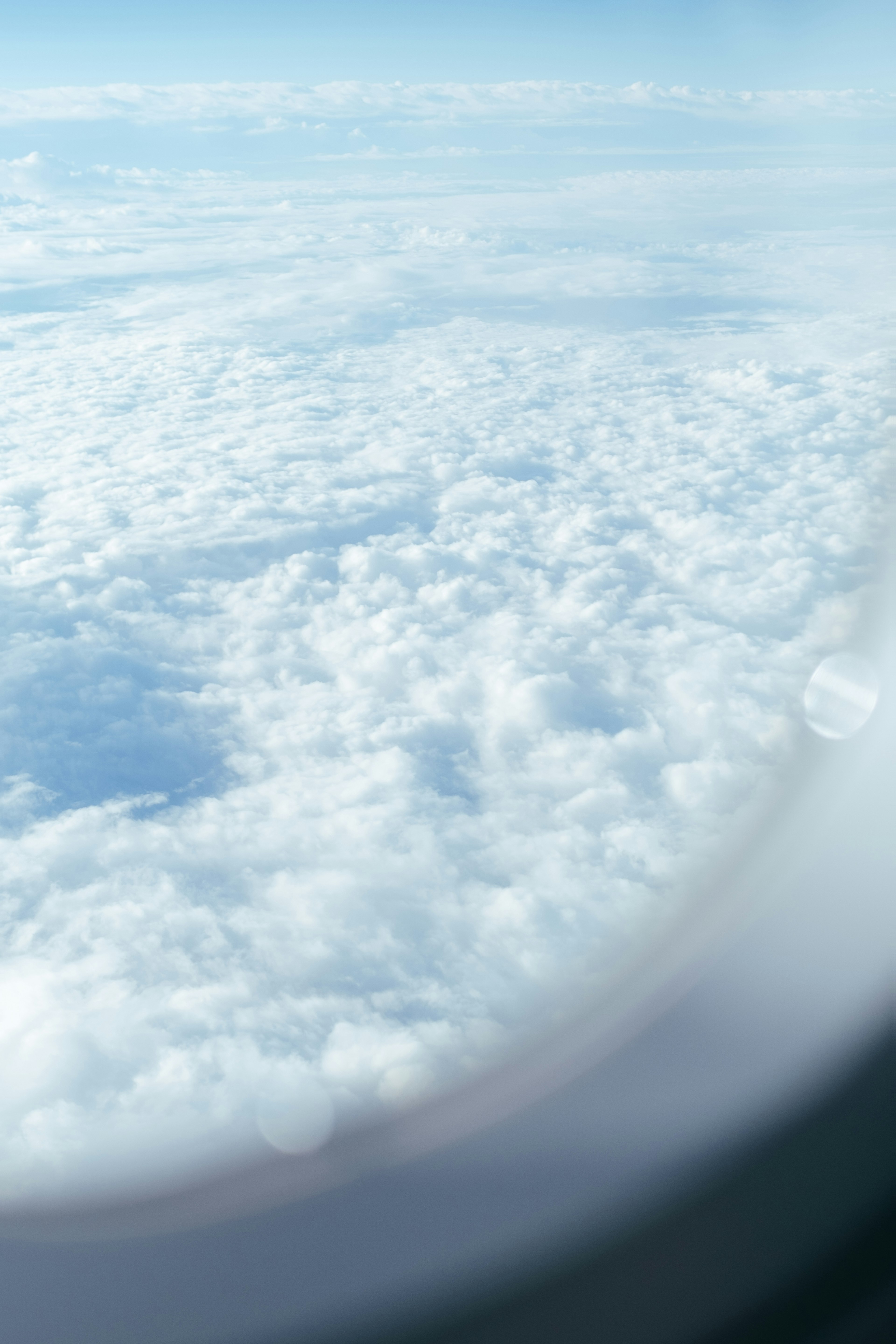 飛行機の窓から見た雲海と青空の景色