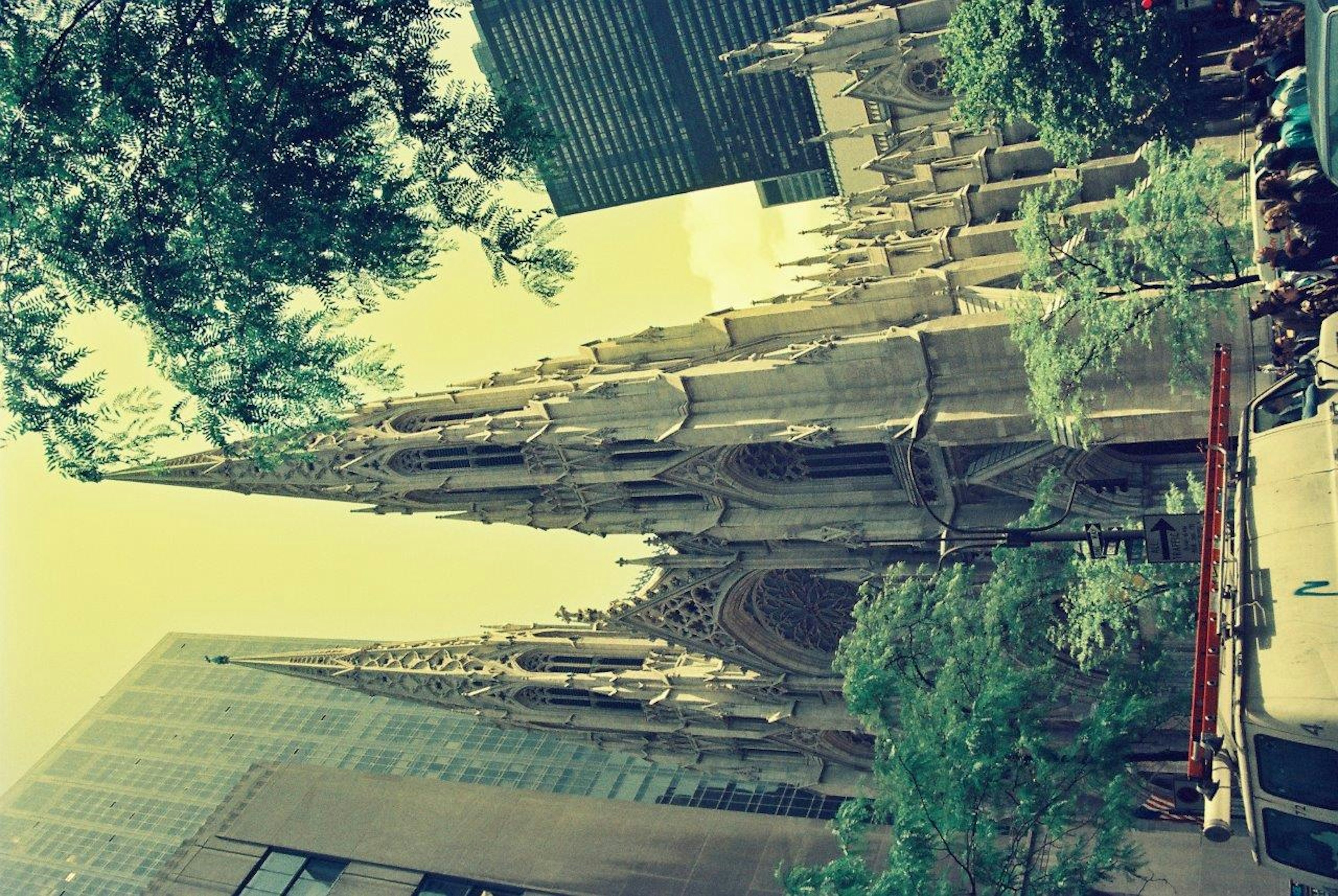 Une vue présentant un bâtiment moderne à côté d'une cathédrale historique entourée d'arbres verts