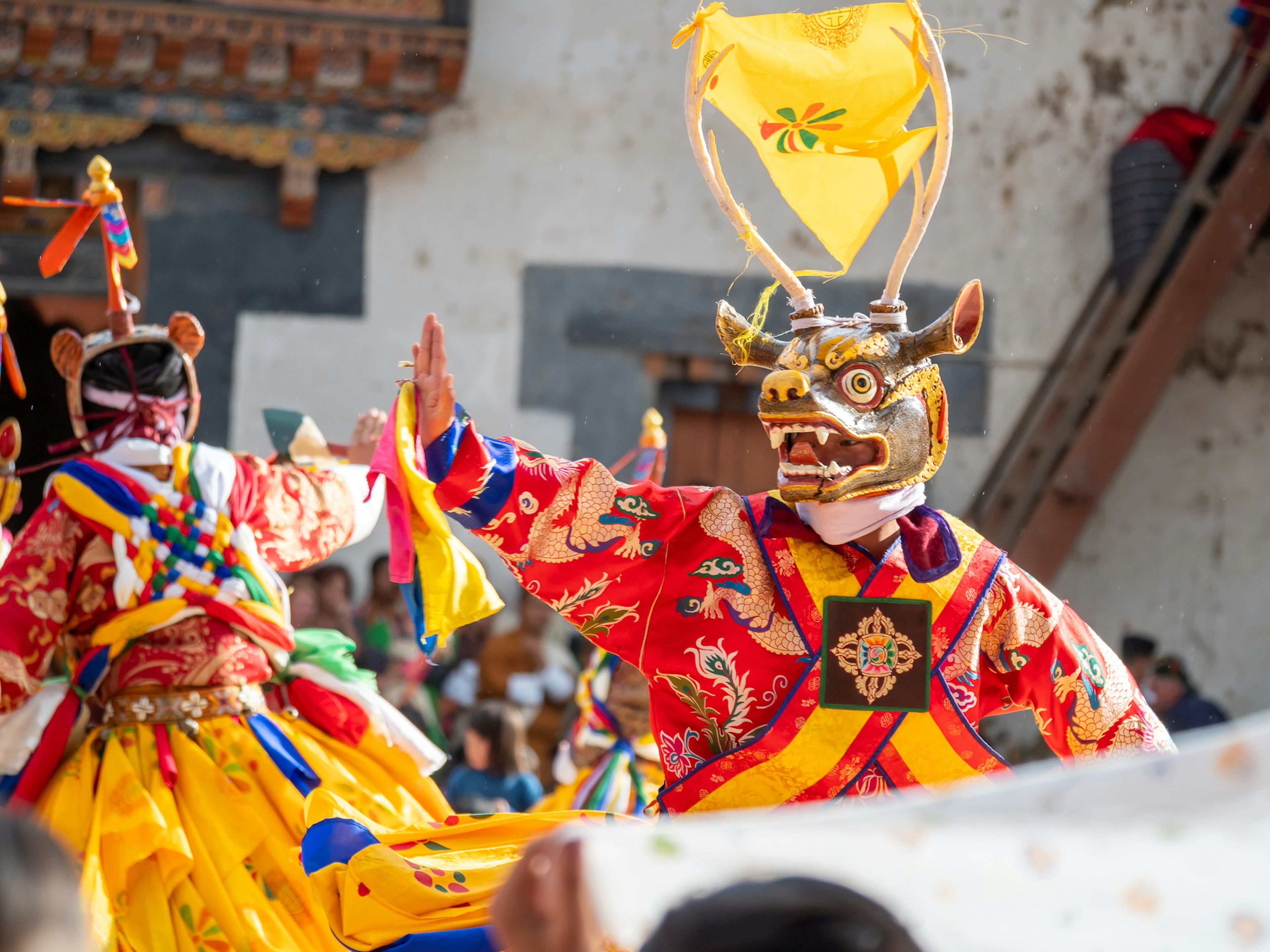 Danzatori in costumi tradizionali che si esibiscono con maschere elaborate durante un festival