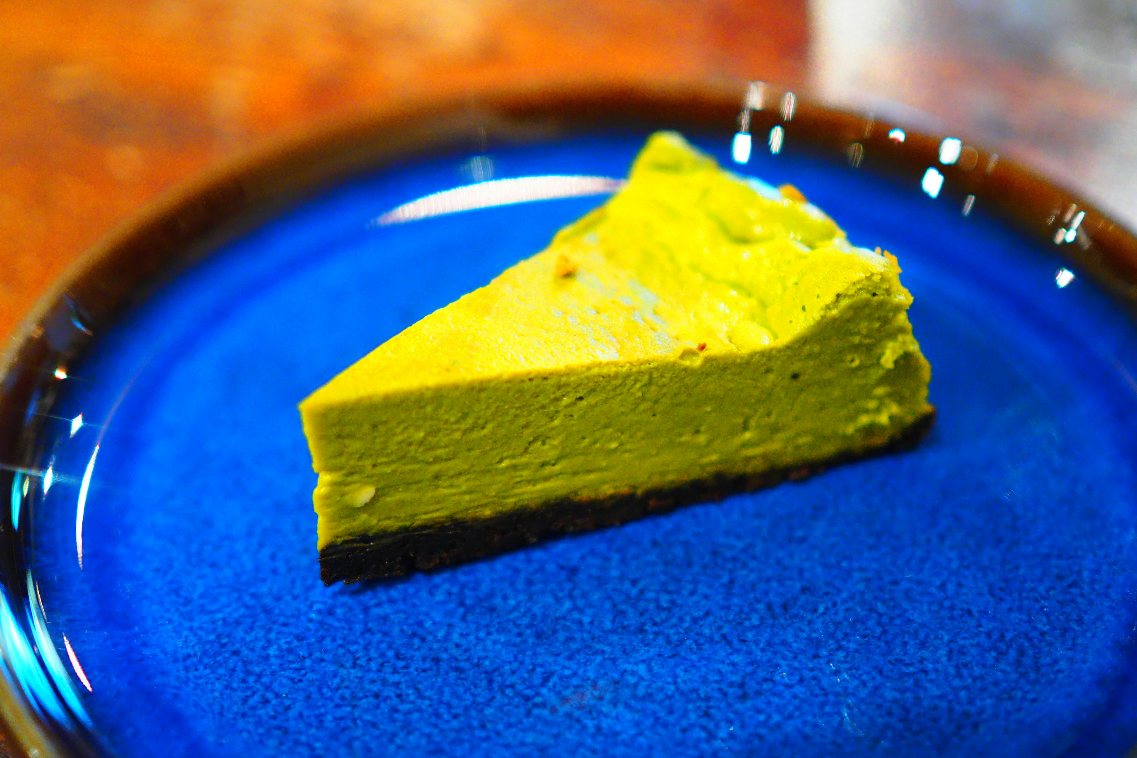 Slice of matcha cake on a vibrant blue plate