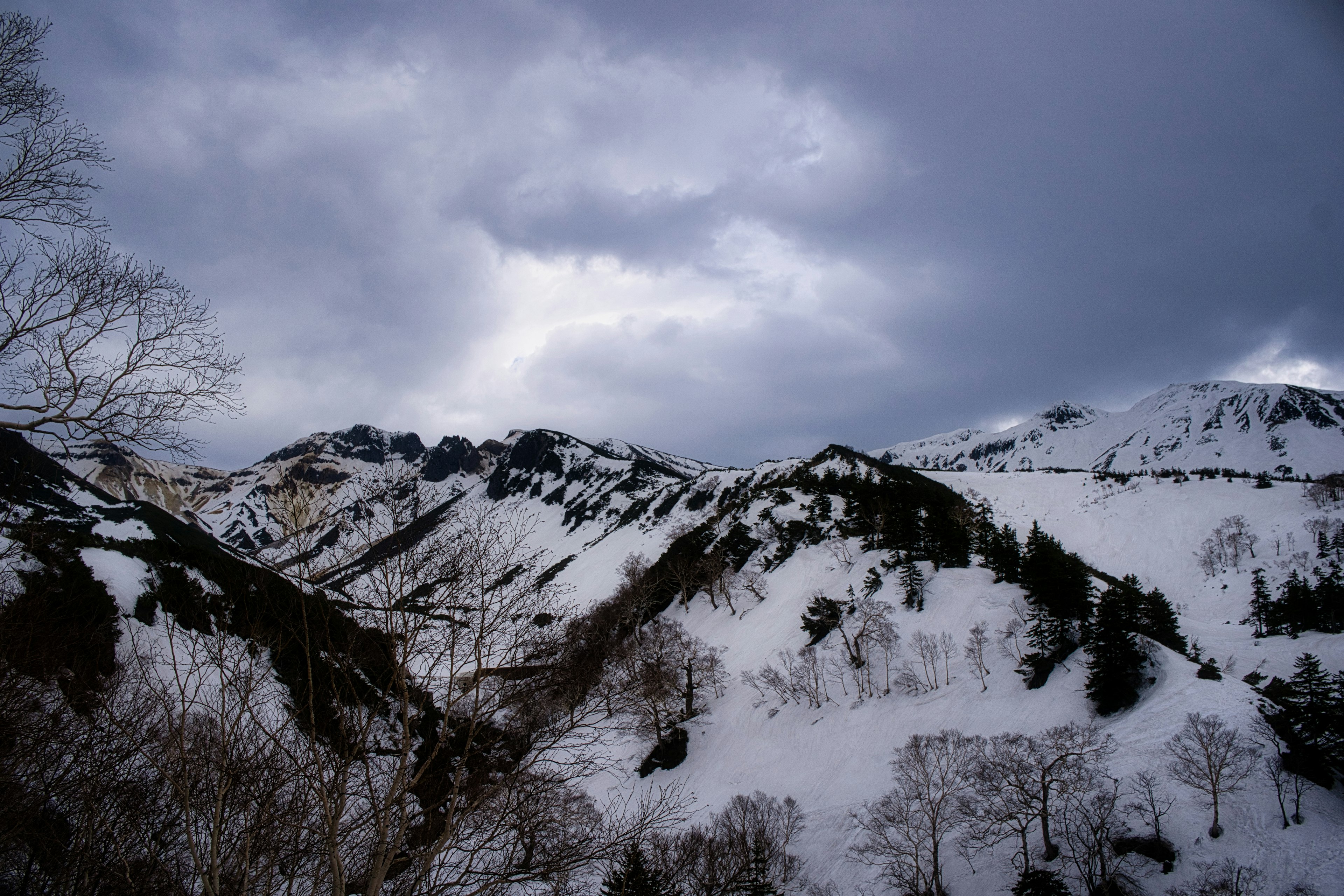 被雪覆盖的山脉在阴暗的云层下