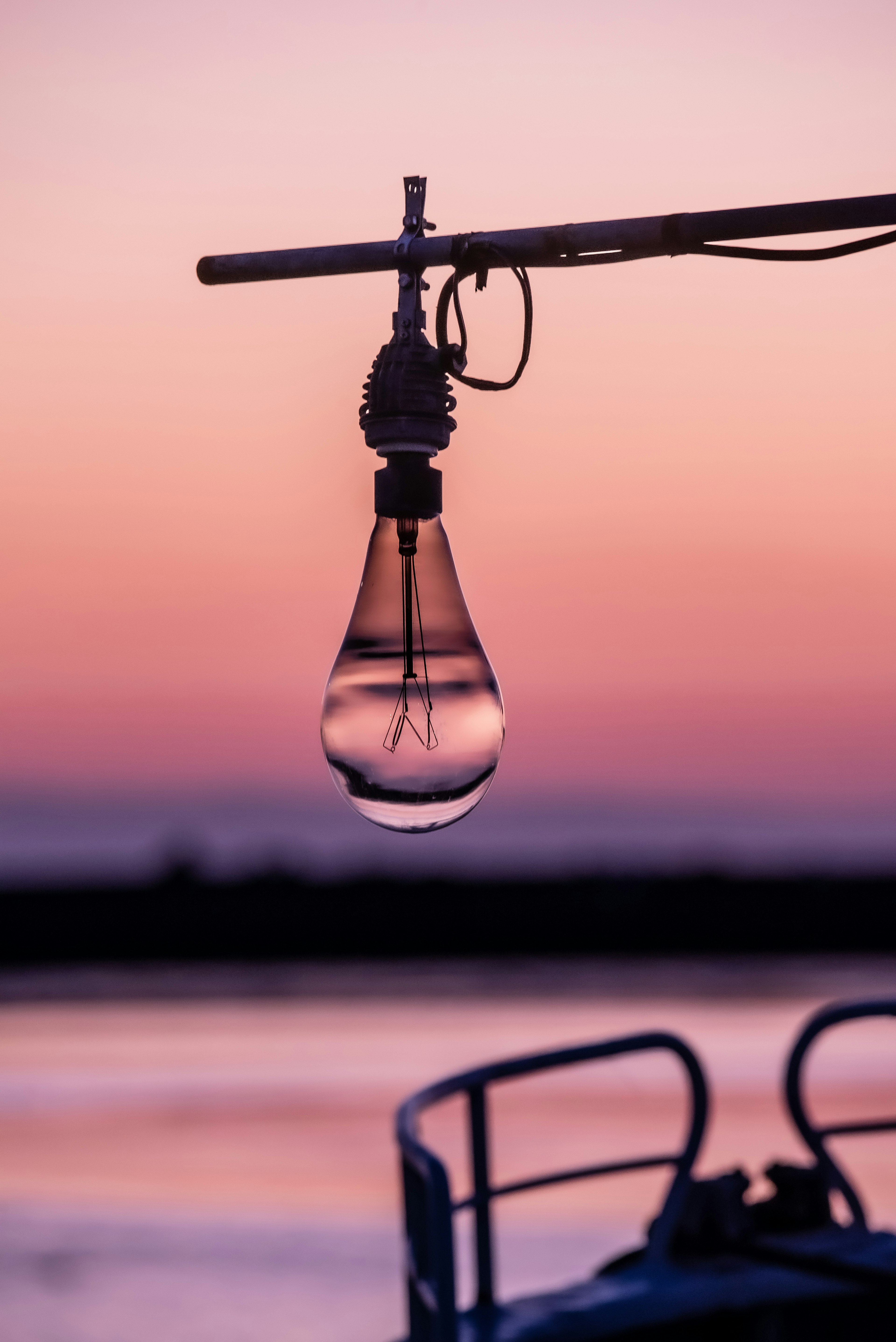 Lampe, die einer Wassertropfen ähnelt, hängt vor einem Sonnenuntergangshimmel