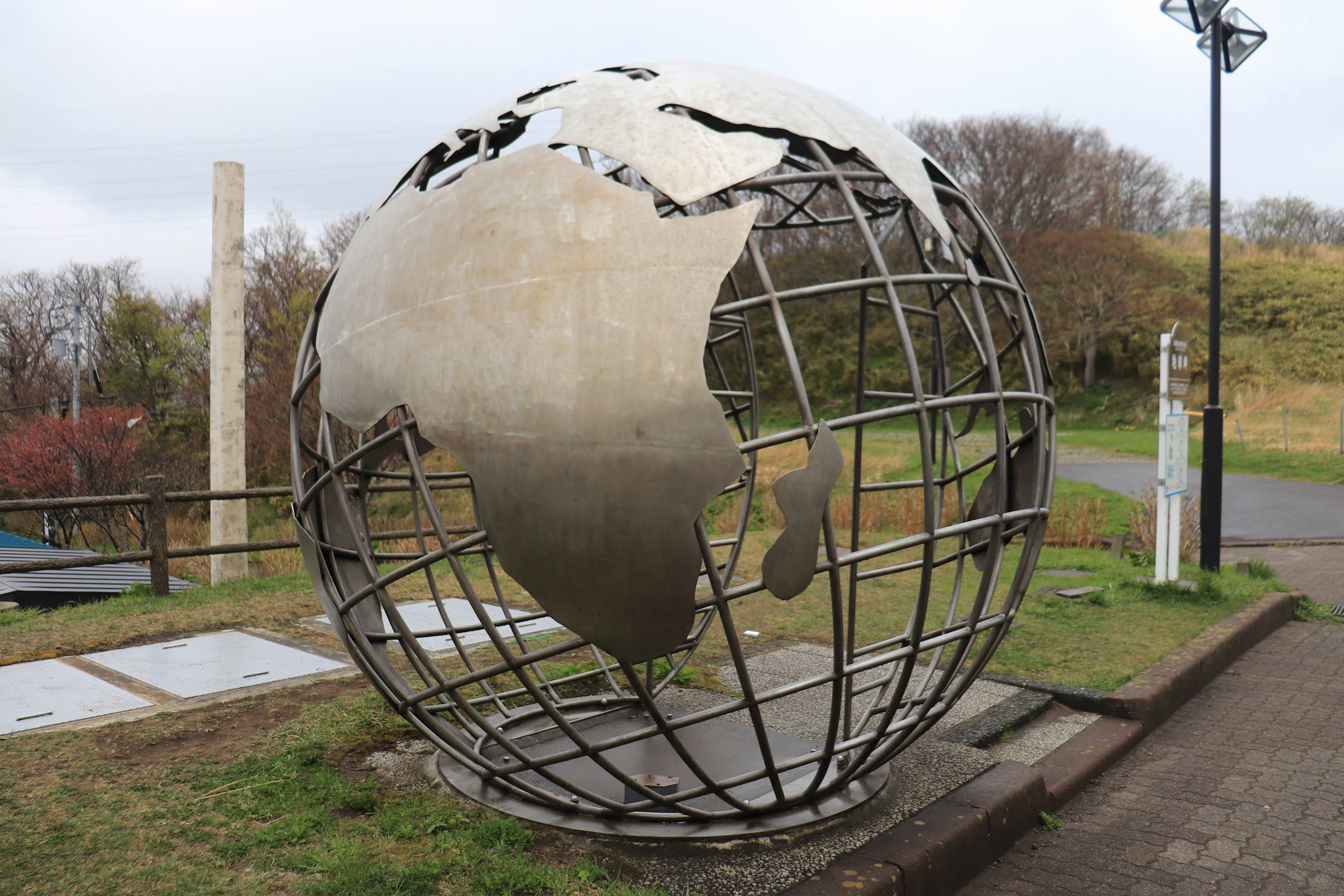 Escultura de metal en forma de globo que muestra África y Corea del Sur