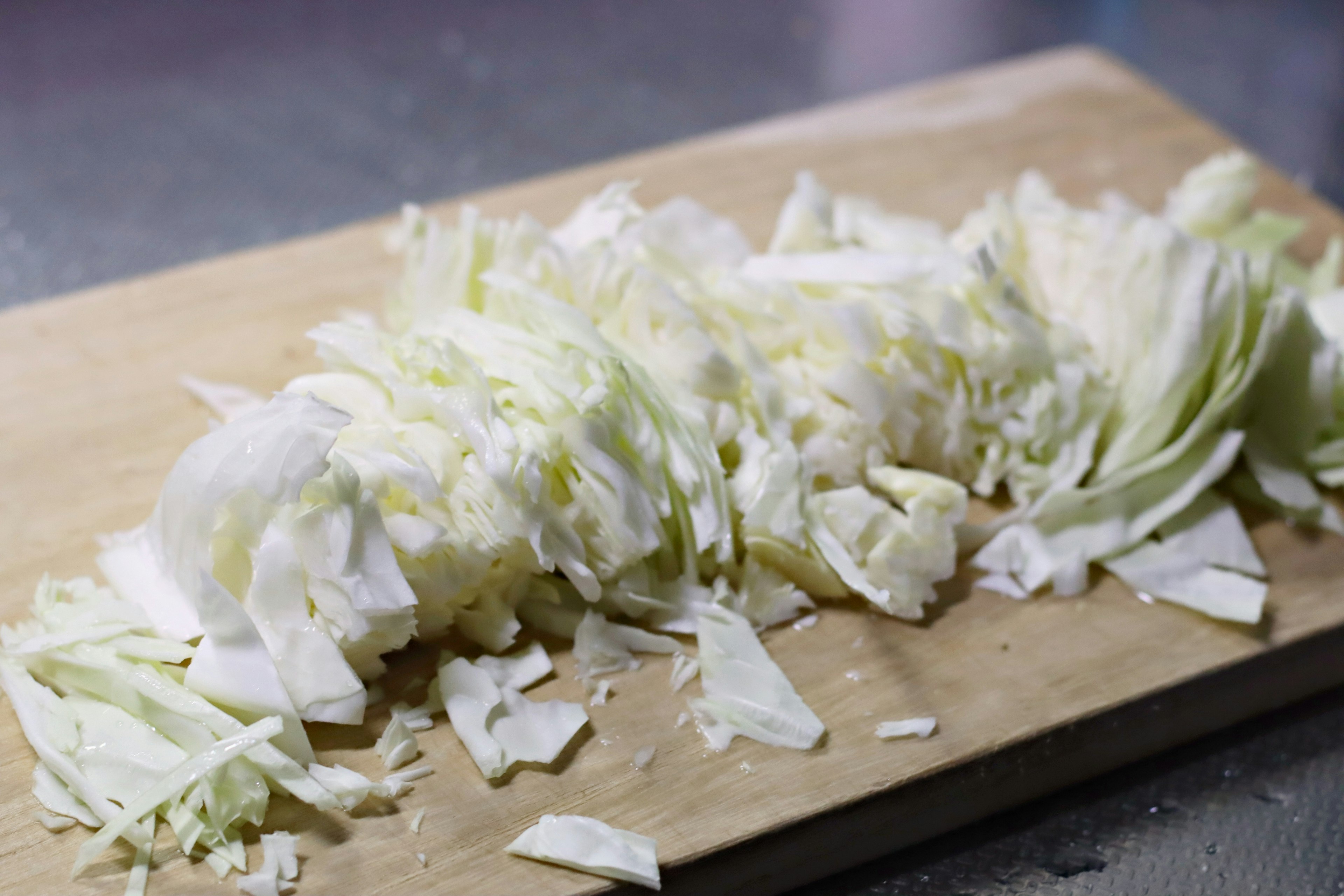 Shredded cabbage on a wooden cutting board