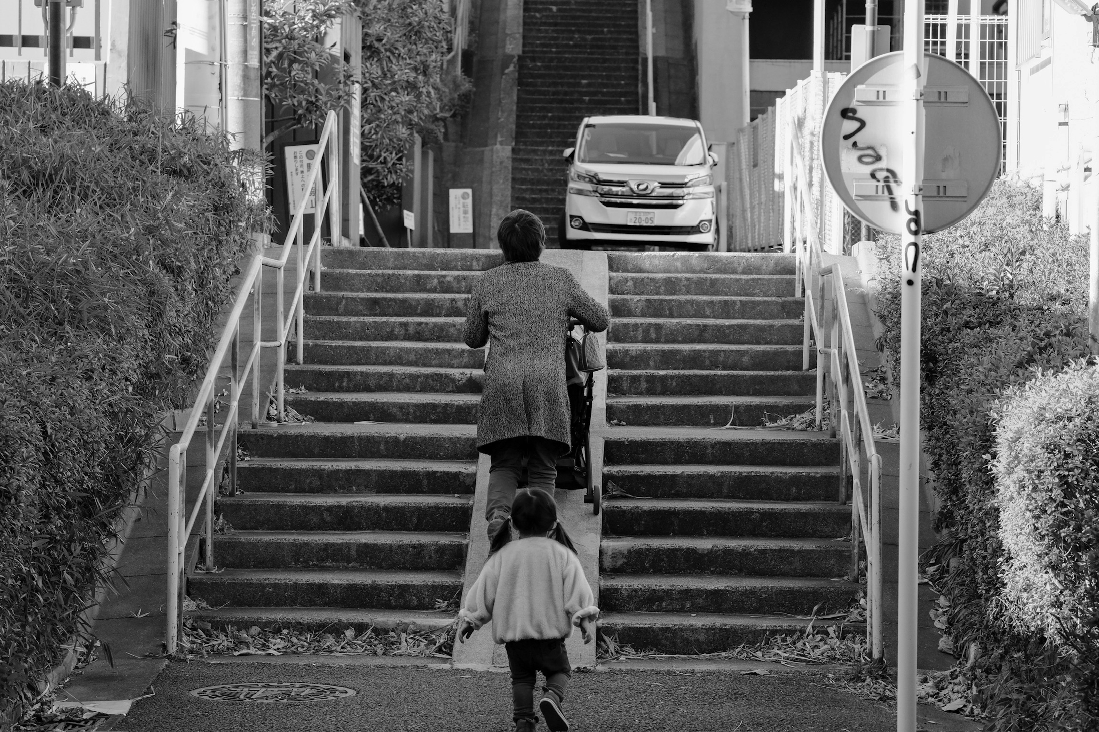 Woman and child walking up stairs in black and white