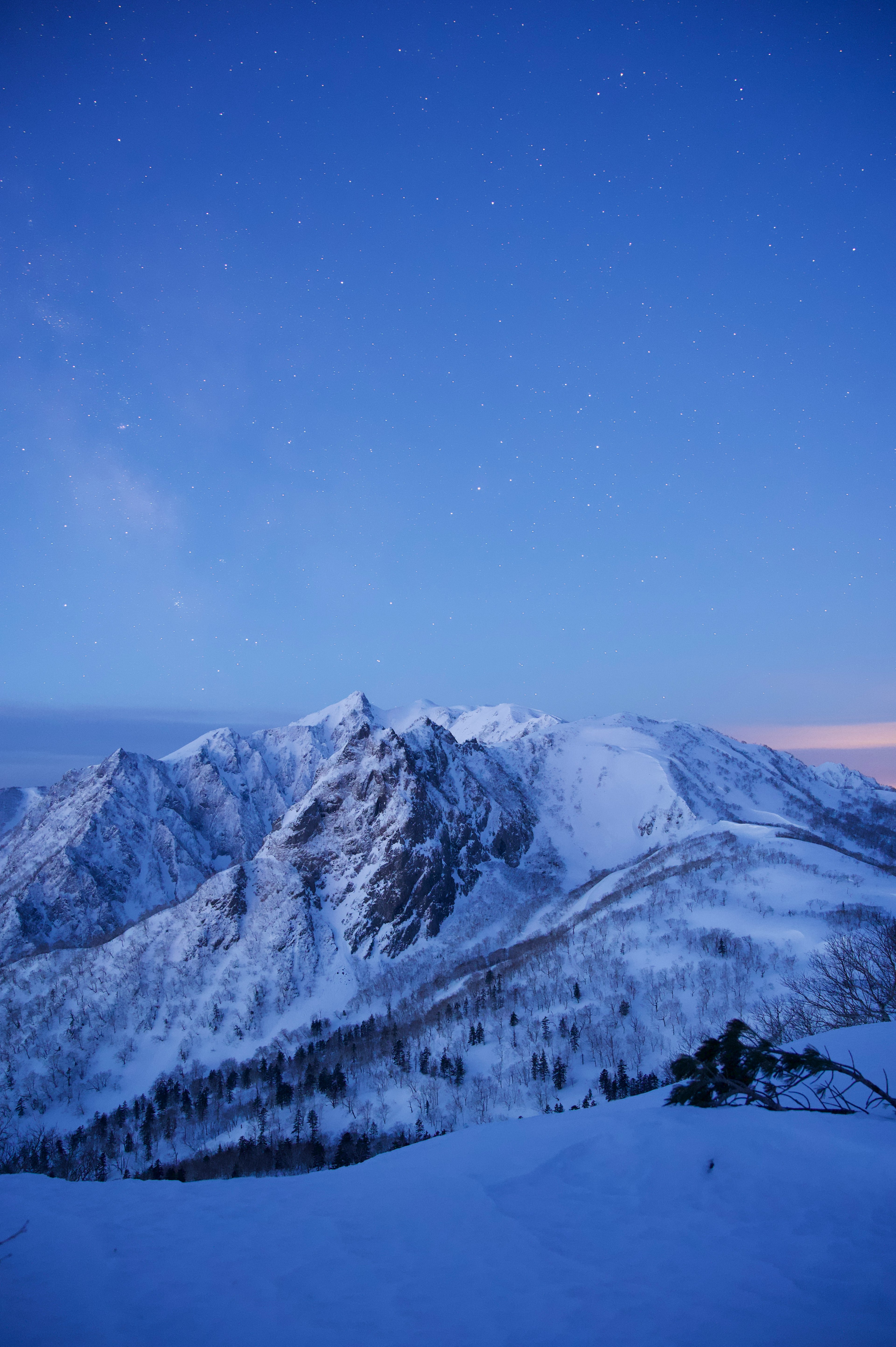 雪に覆われた山々が青い空の下に広がる美しい風景