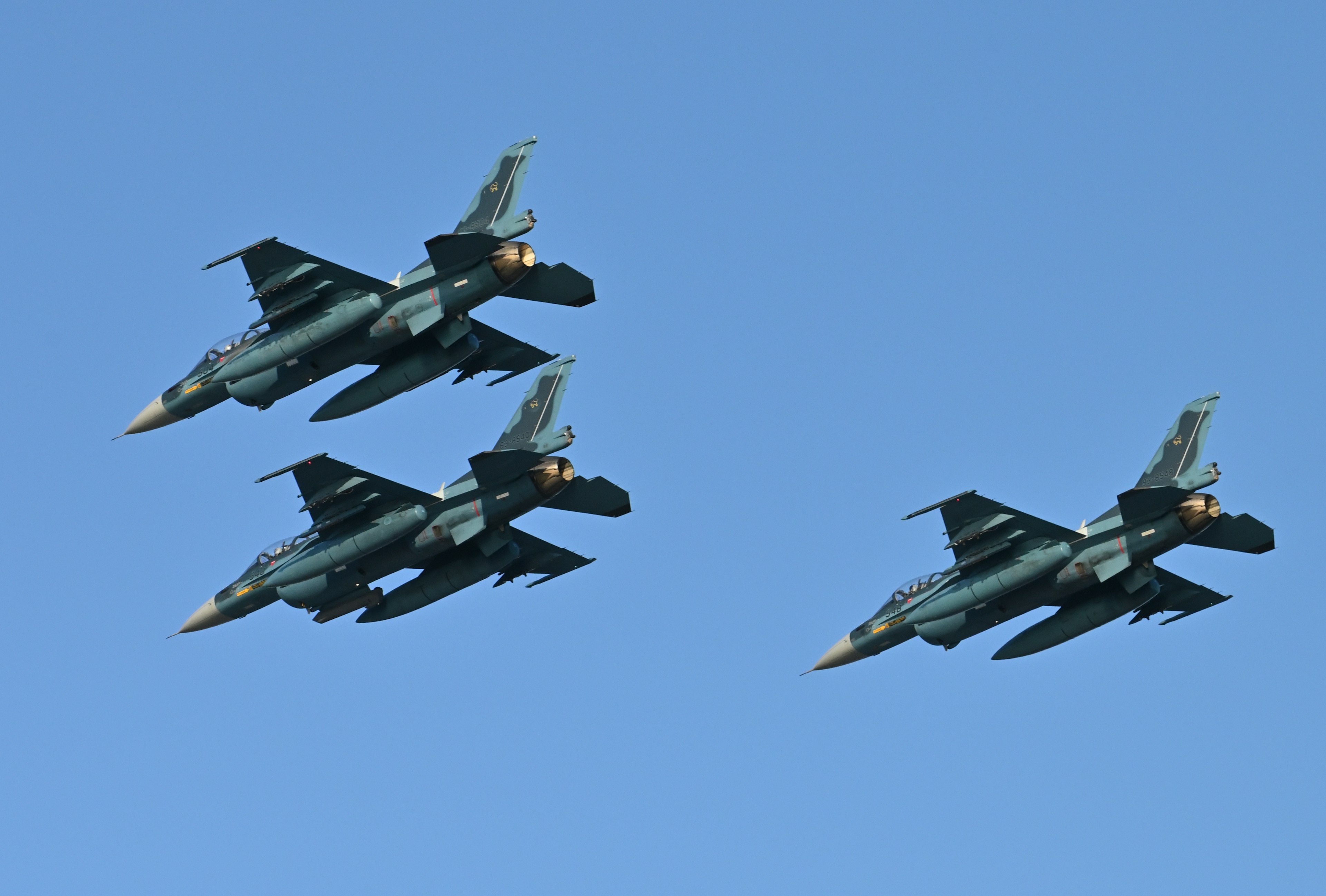 Tres aviones de combate volando en un cielo azul