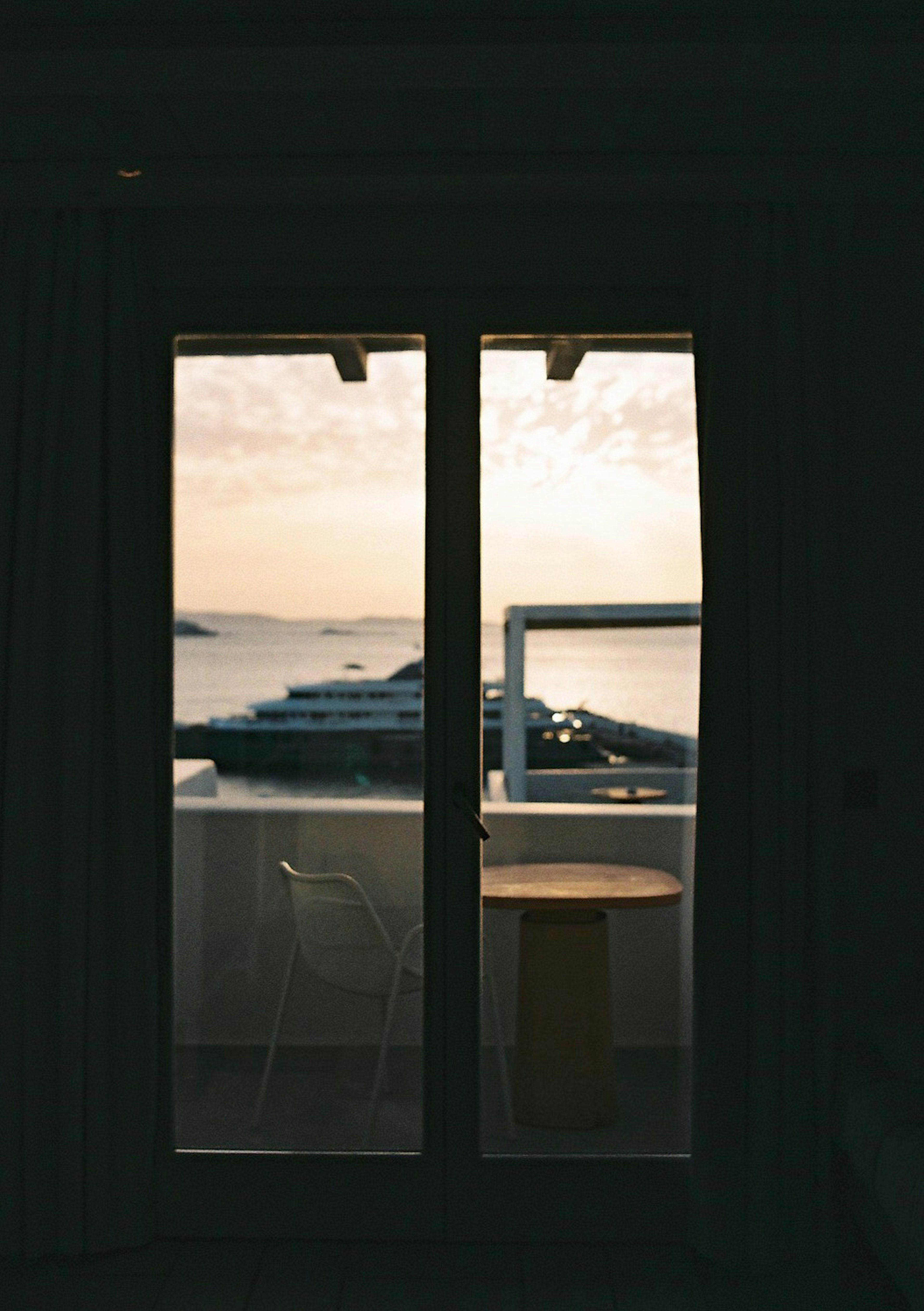 Vista del mar y del cielo al atardecer a través de las puertas del balcón