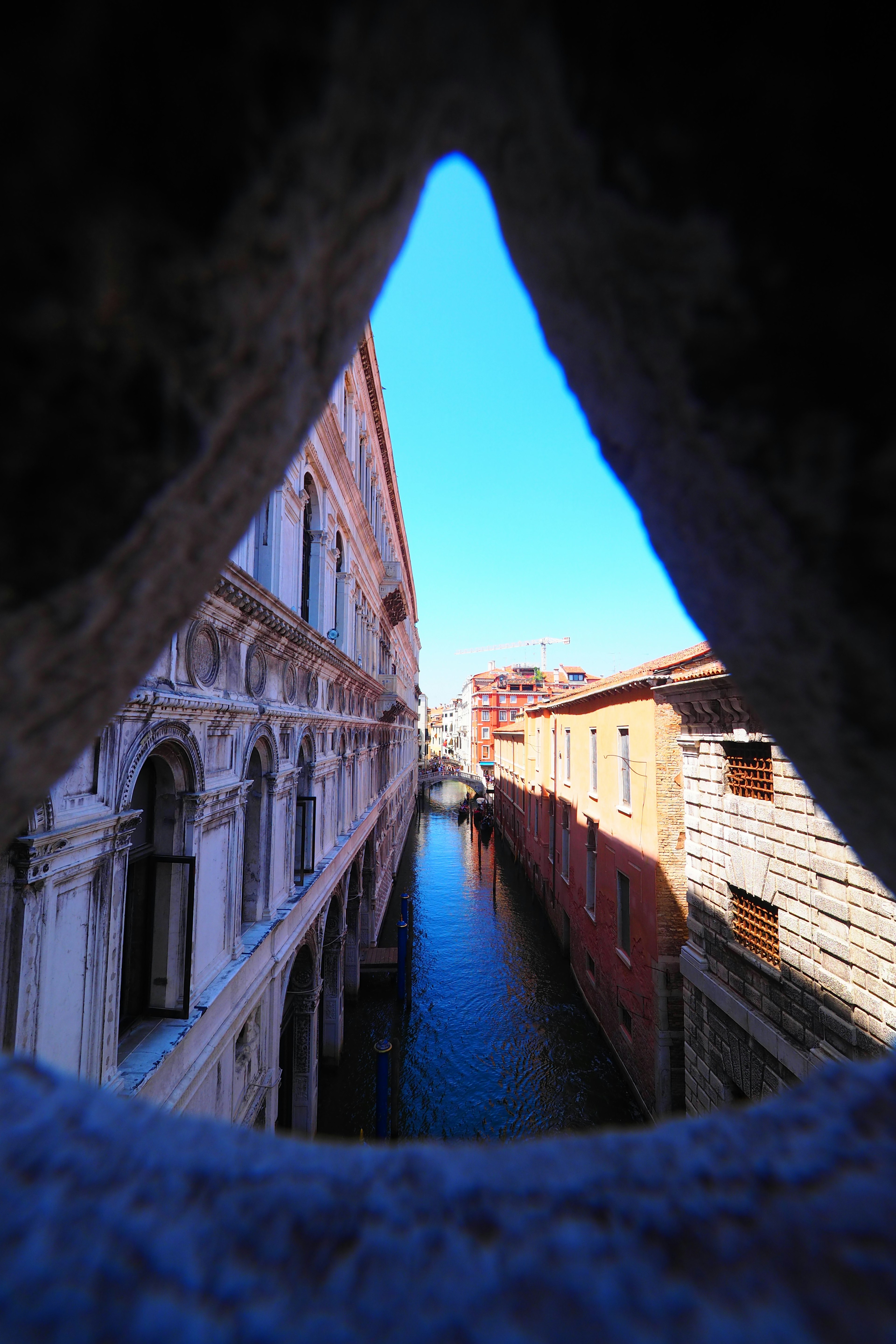 Blick auf einen venezianischen Kanal durch ein Steinbogenfenster