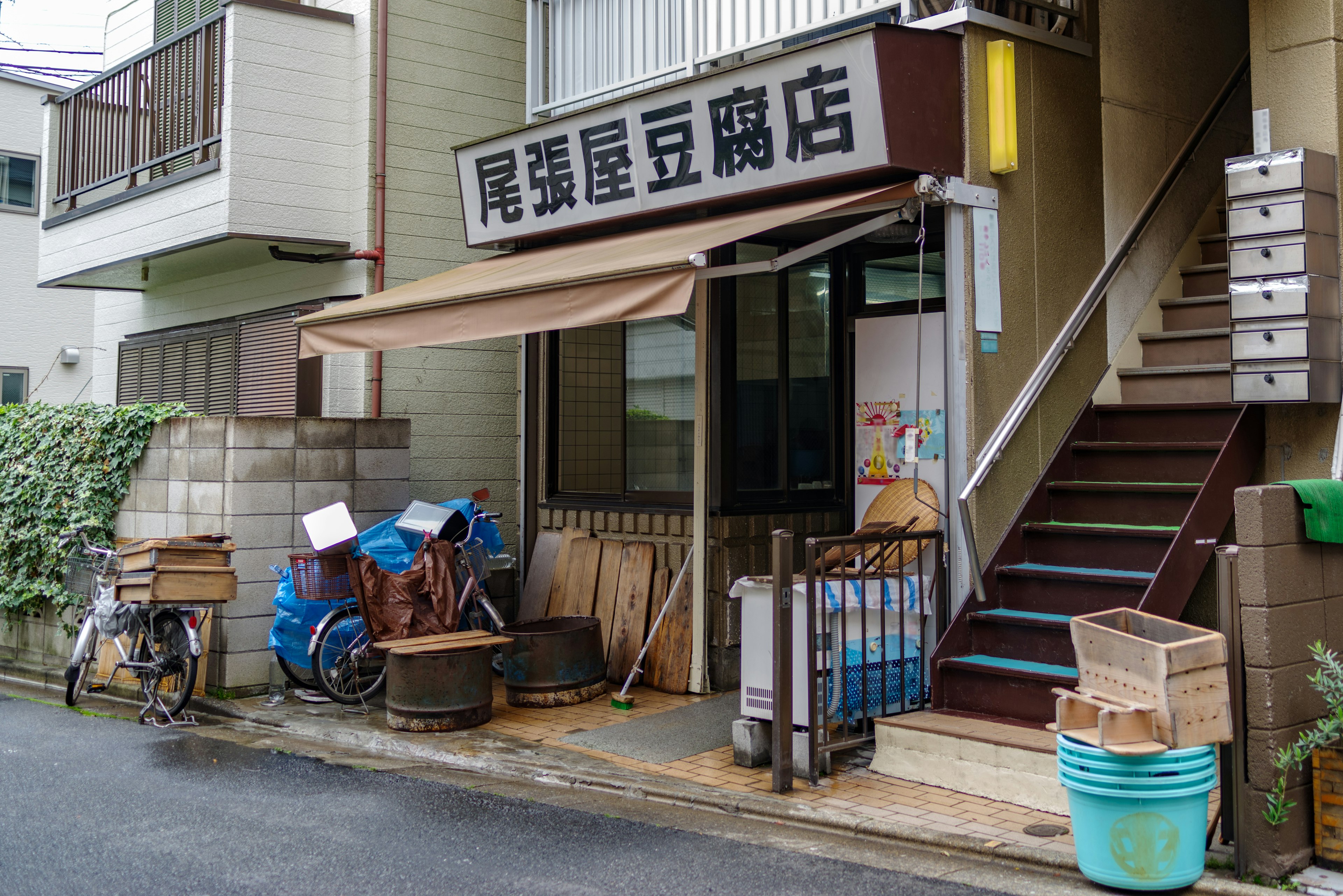 Vue extérieure d'un magasin avec des escaliers vélo et divers objets à l'extérieur