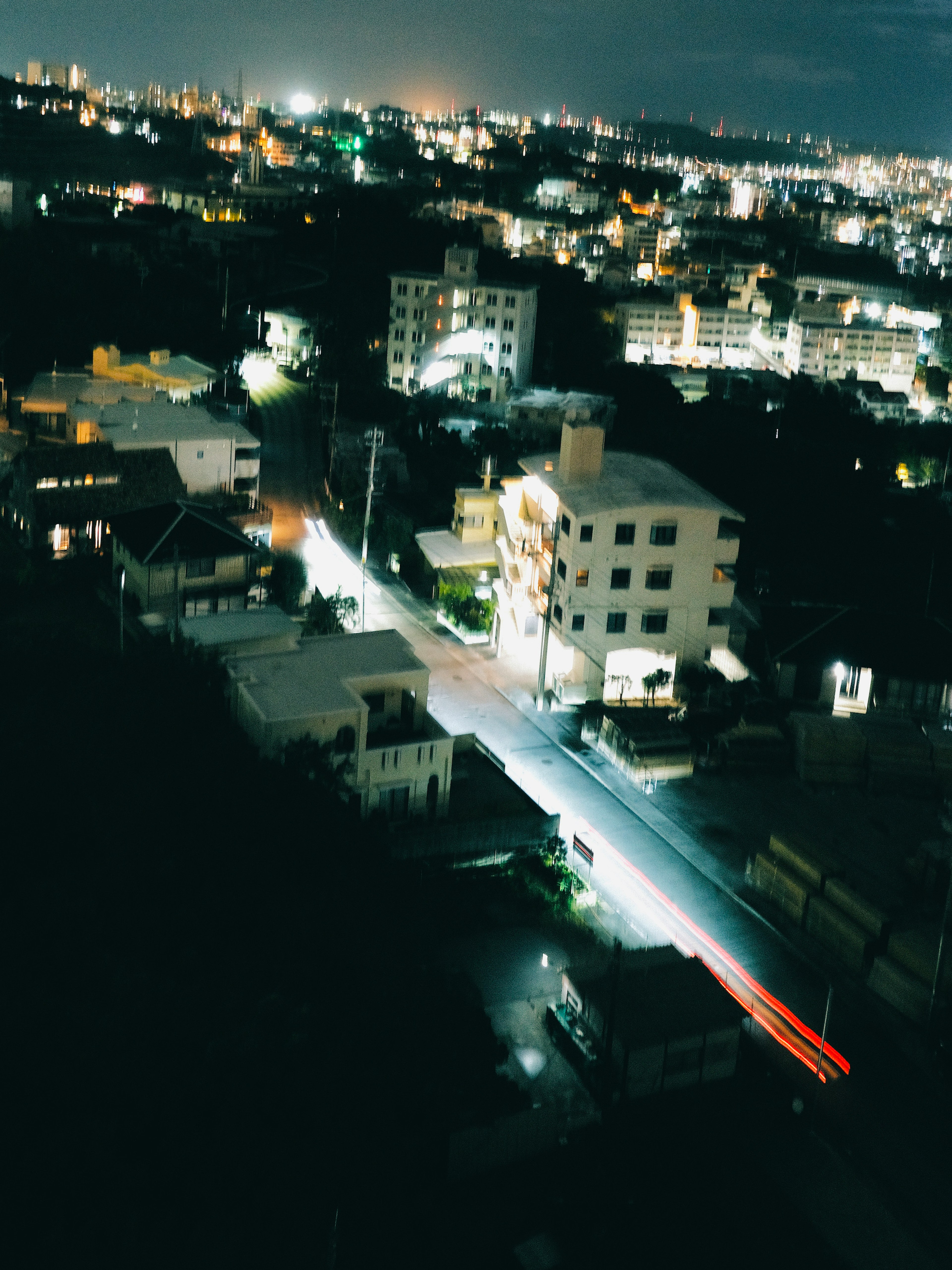 Nachtstadtansicht mit Wohngebäuden und Straßen, beleuchtet von Stadtlichtern