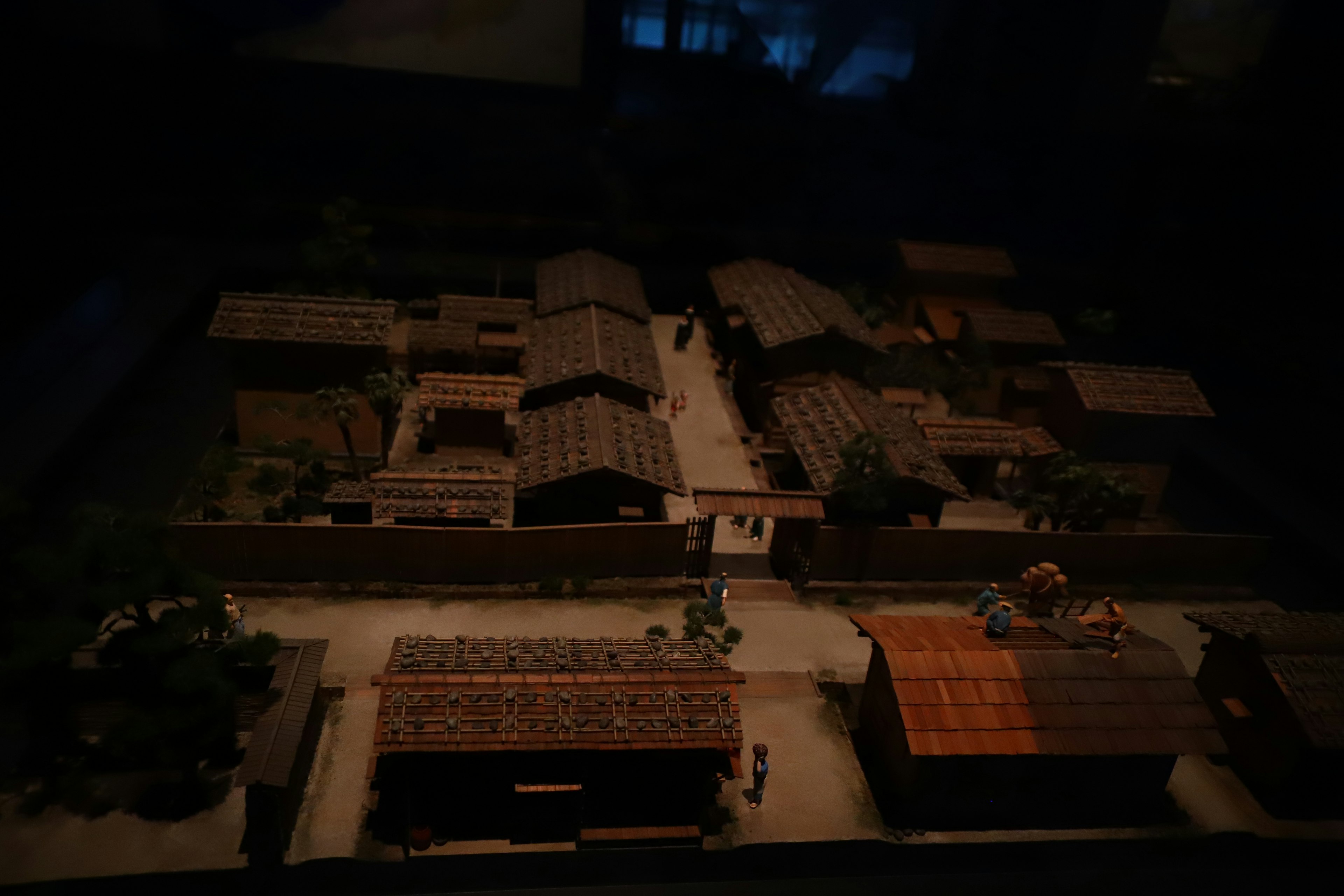 Scène de village miniature avec des maisons à toit de chaume et des arbres environnants