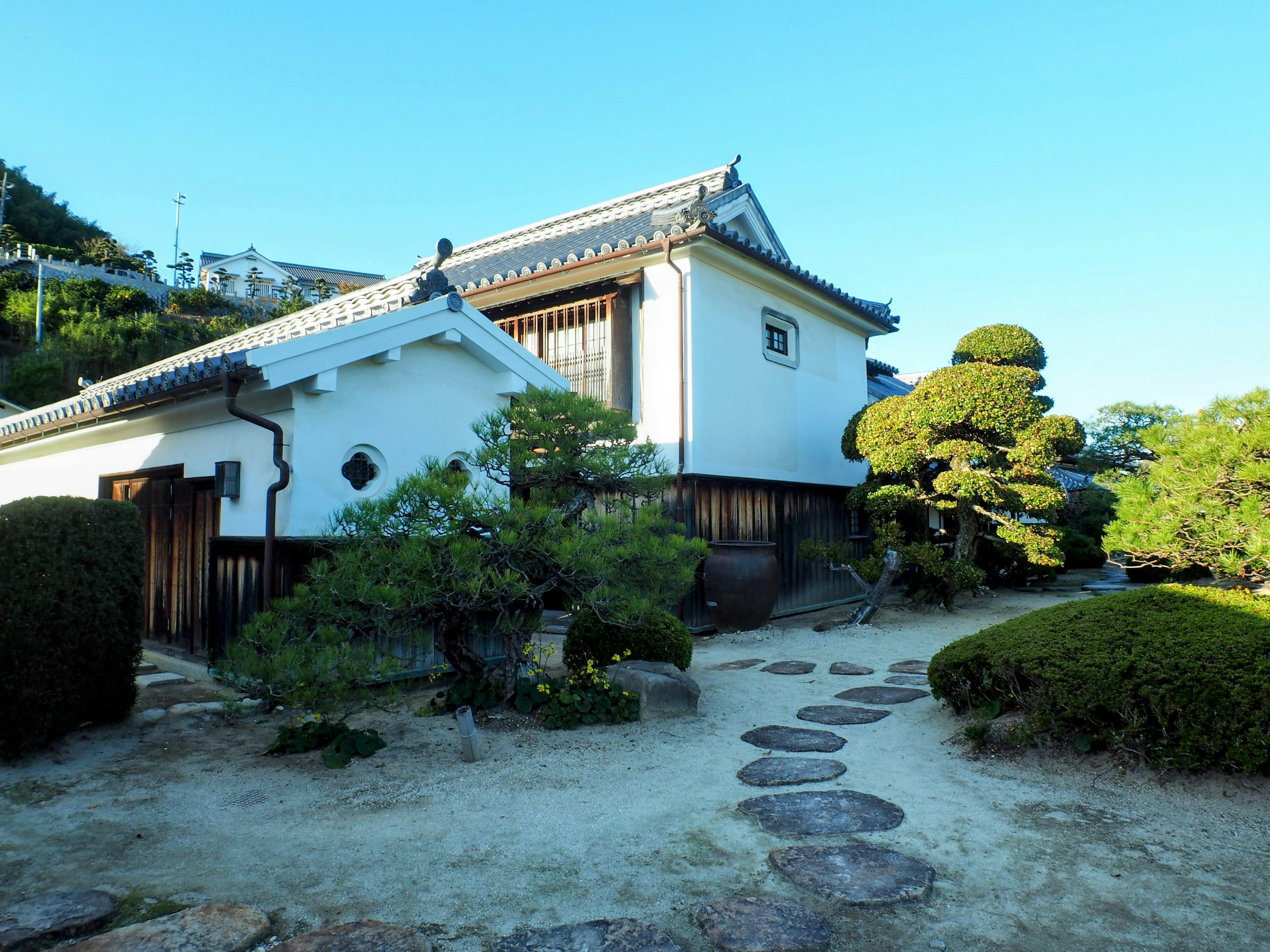 传统日本房屋与白色墙壁和修剪整齐的花园