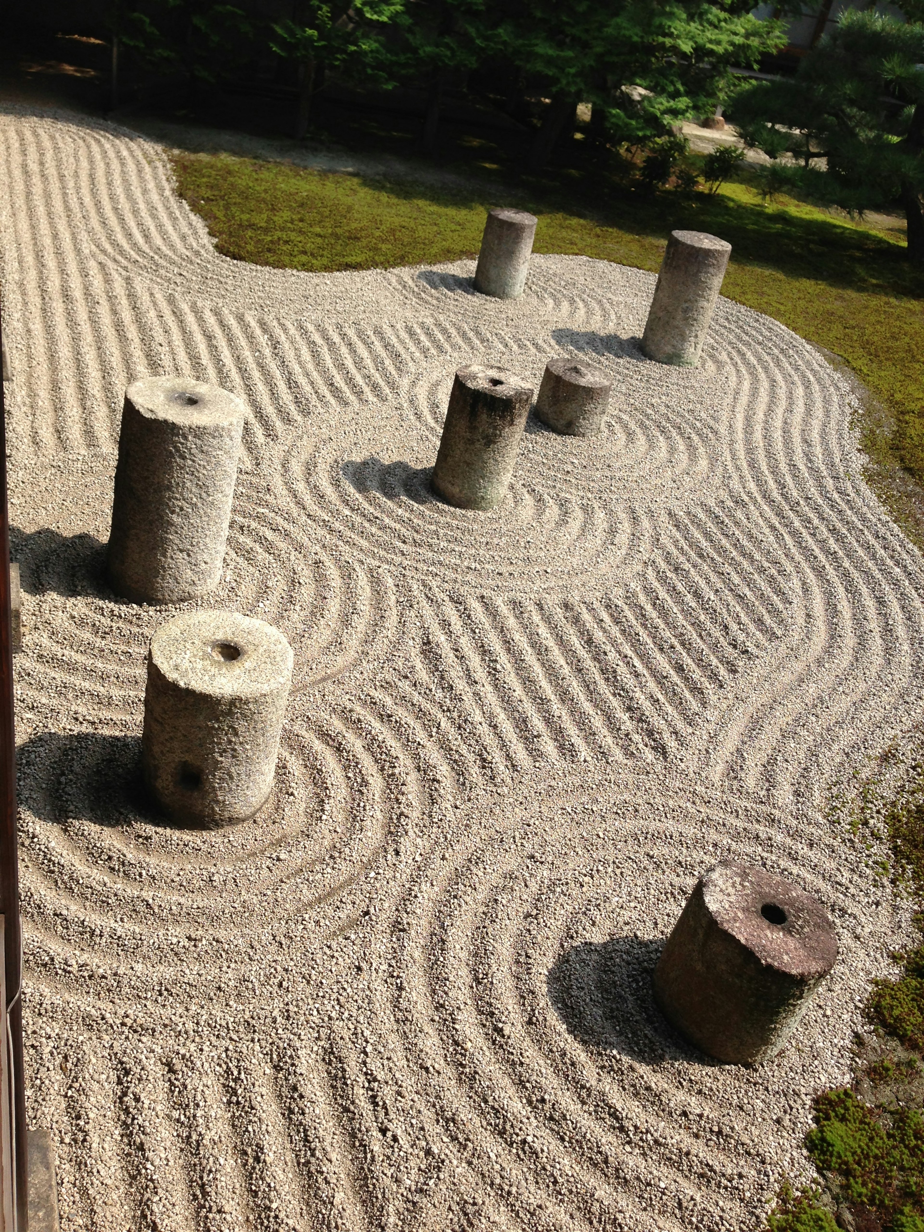 Paisaje de jardín japonés con pilares de piedra y patrones de arena intrincados